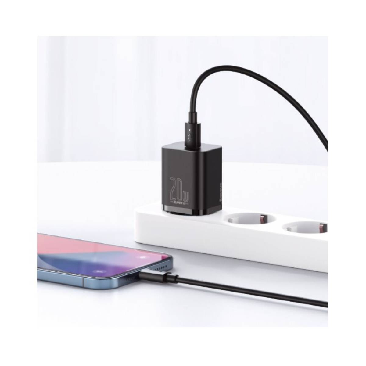 Czarna ładowarka jest podłączona do gniazdka ściennego, z podłączonym telefonem do ładowania.