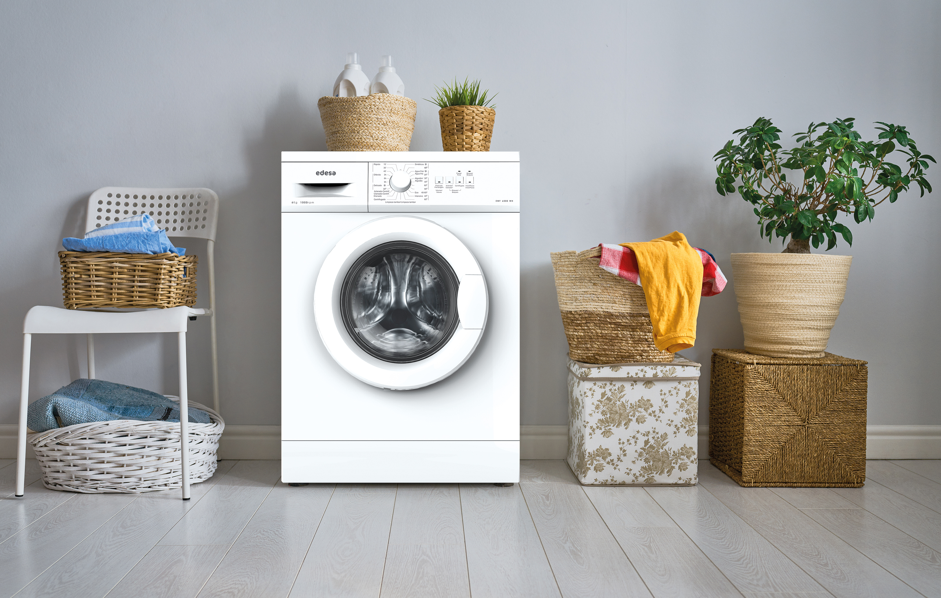 Una lavadora blanca con ropa y plantas en un cuarto de lavado.