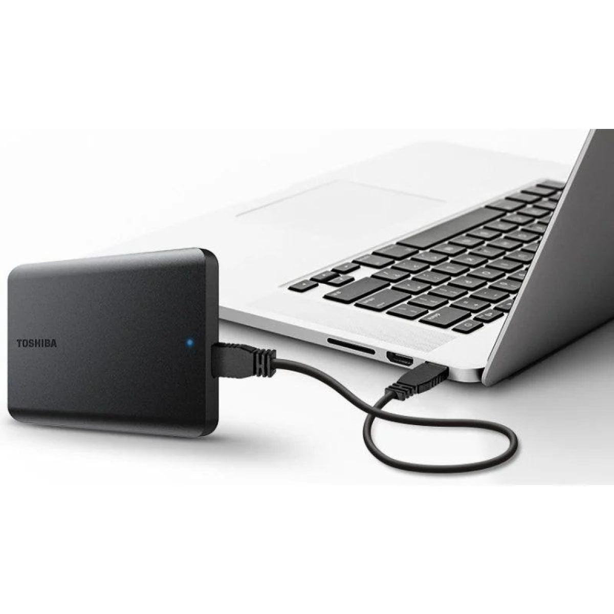 Un disque dur externe noir connecté à un ordinateur portable via un câble USB.