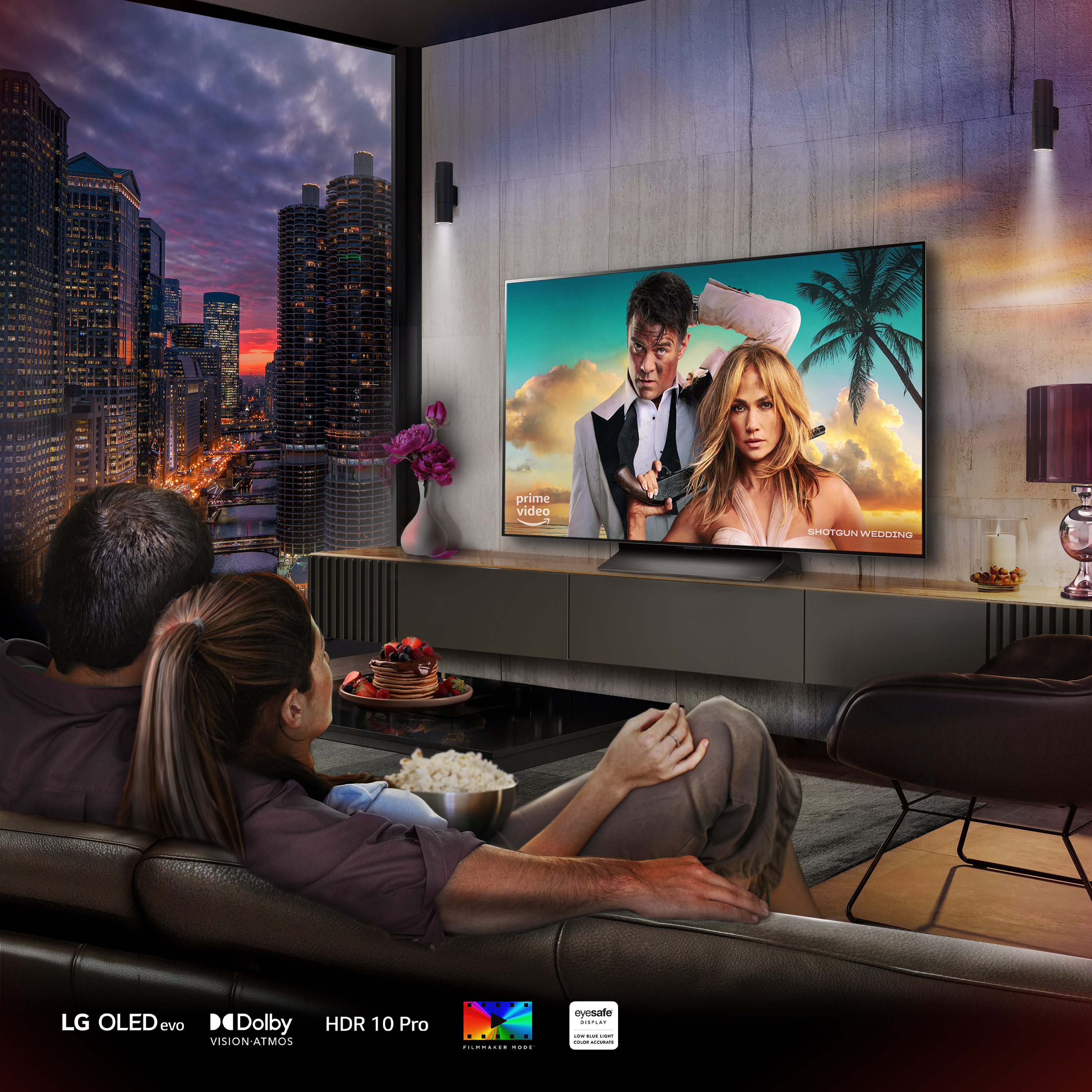 Dos personas en un sofá ven una película en la TV. La pantalla muestra una escena de la película.