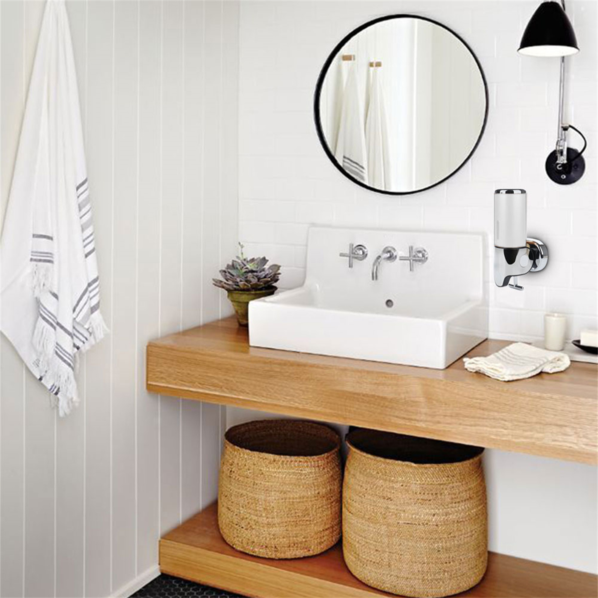 Ein modernes Badezimmer mit Waschbecken, Spiegel, Handtüchern und Seifenspender.