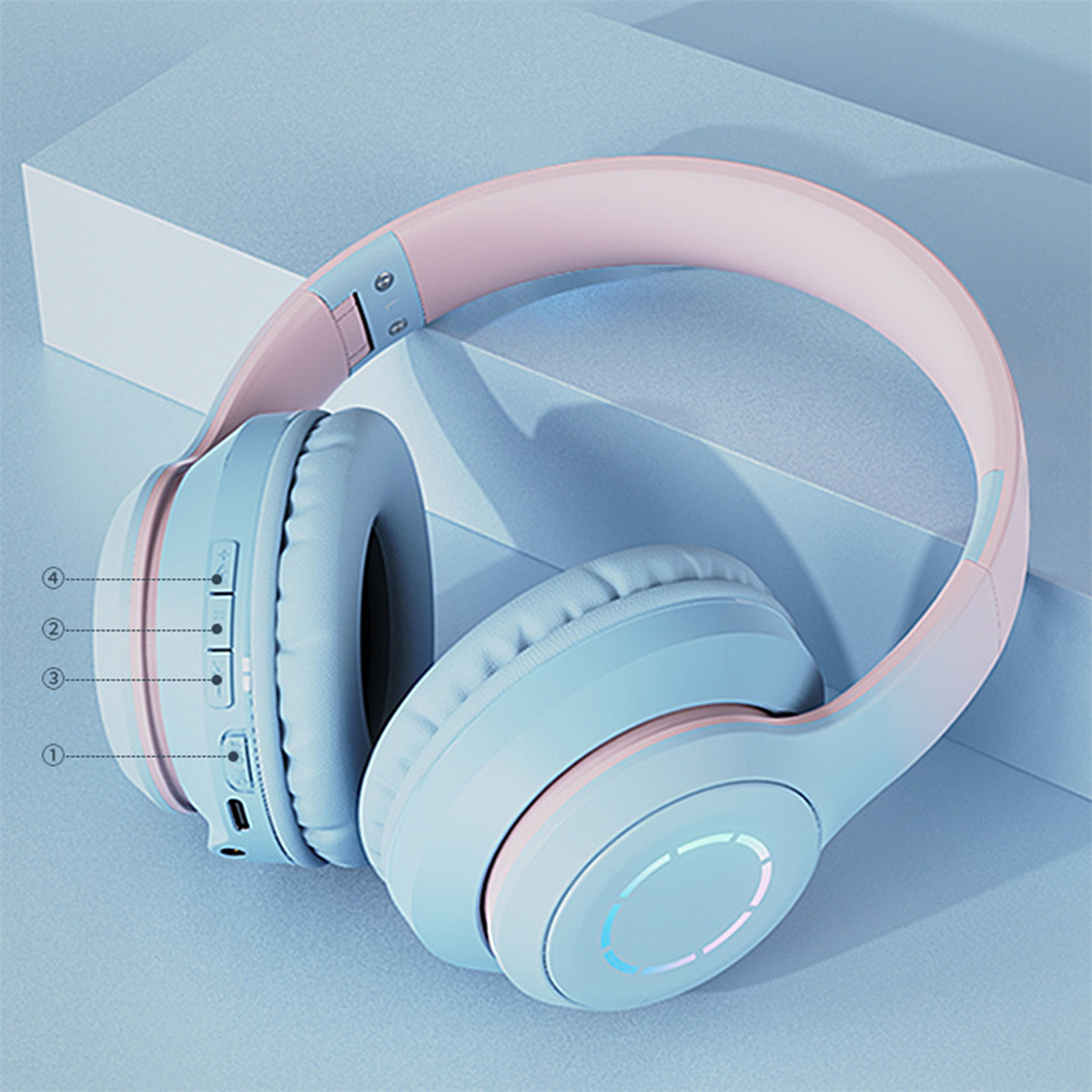 Blaue und rosa Kopfhörer mit Bedienelementen und einem leuchtenden Kreis.