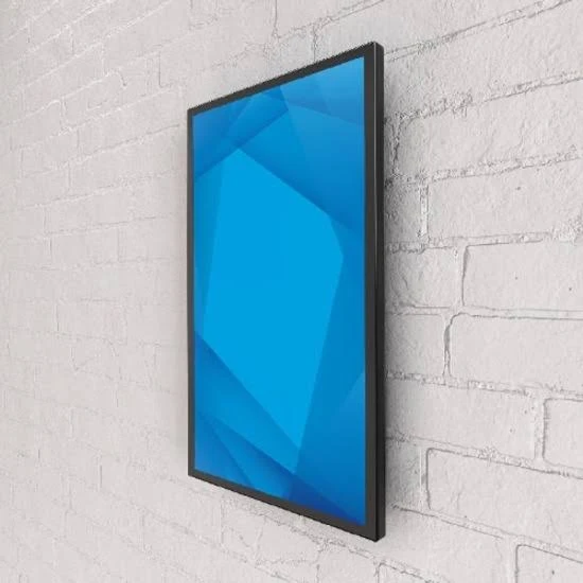 Niebieska sztuka geometryczna w czarnej ramie, zamontowana na białej ceglanej ścianie.