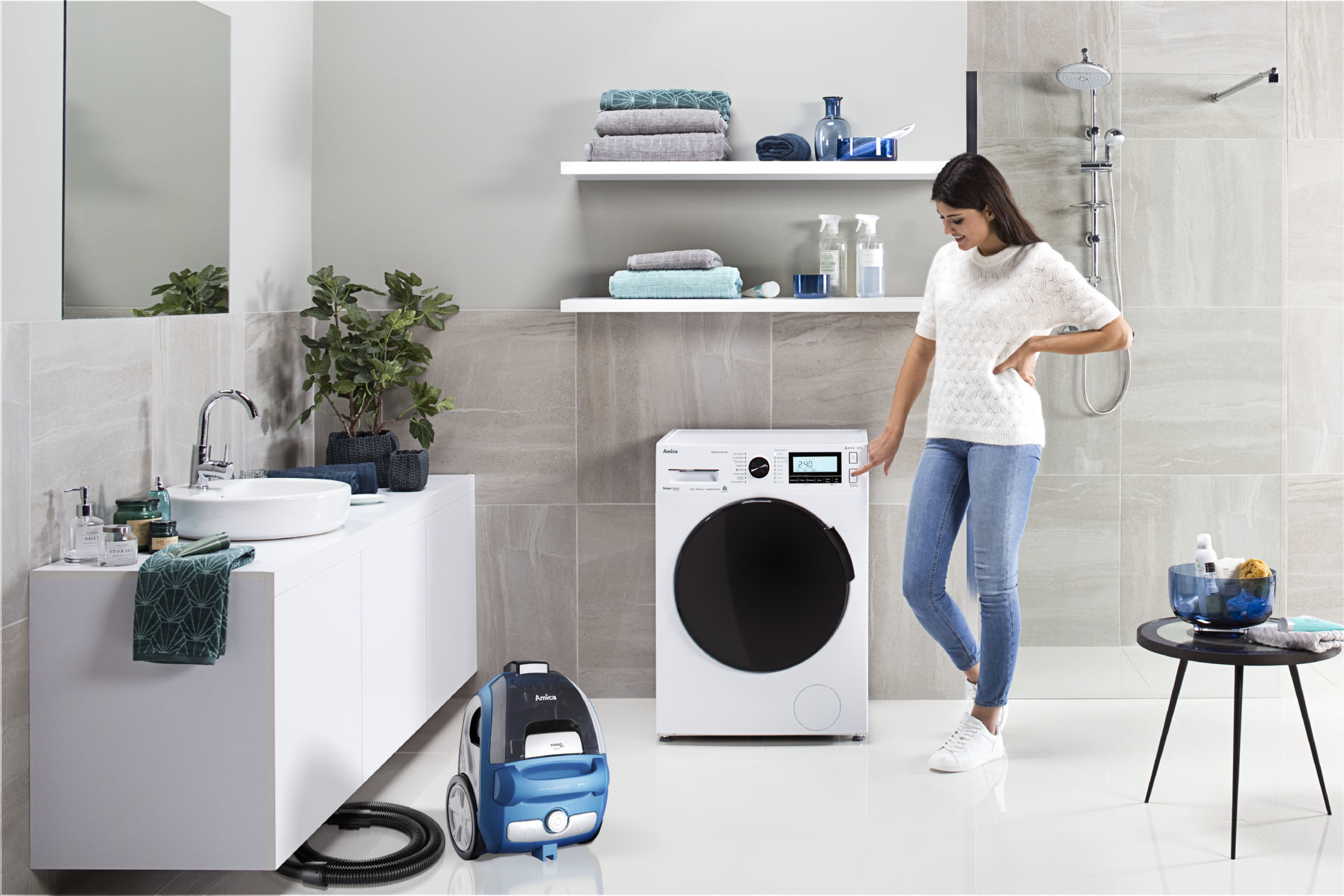 Kobieta w łazience w pobliżu pralki i odkurzacza.