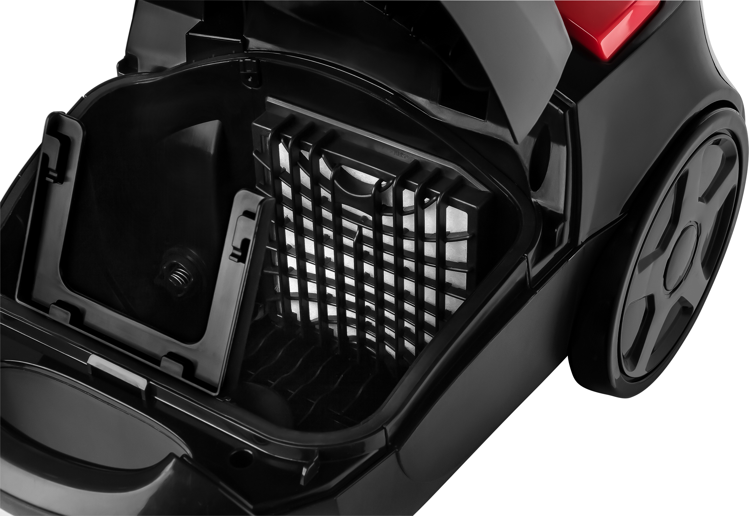 Zbliżenie otwartej komory odkurzacza. Widoczny filtr. Czarne i czerwone kolory.