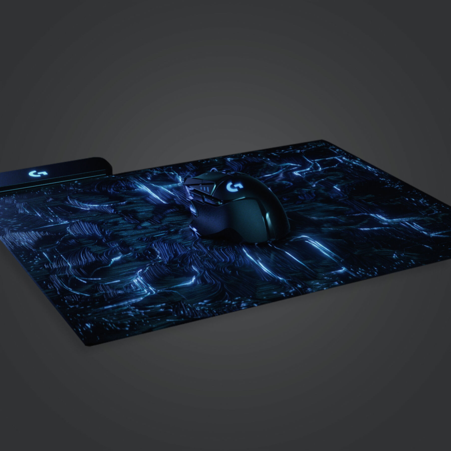 Configurazione di gioco: un mouse, un tappetino per mouse con motivi blu e una superficie nera in un ambiente buio.