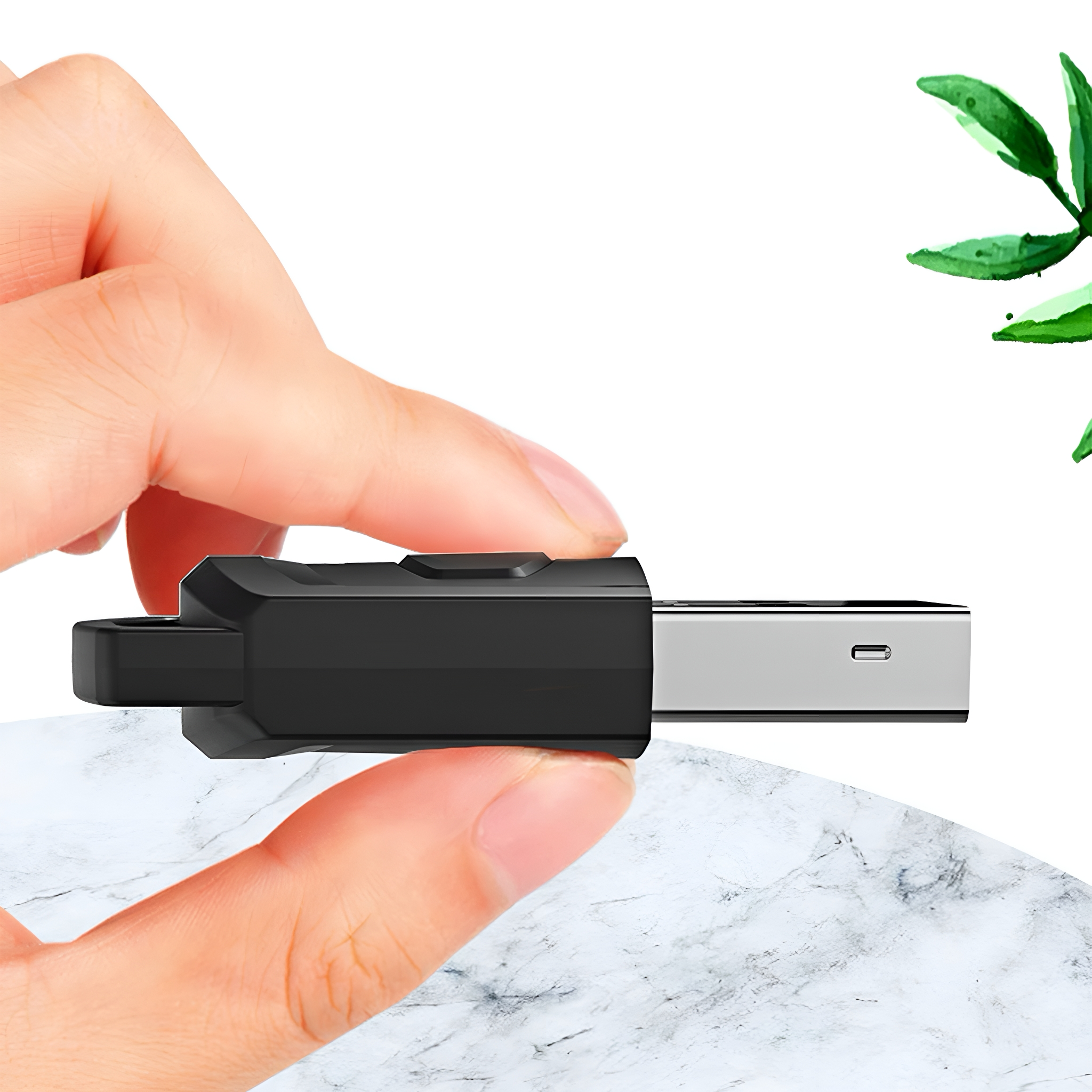 Eine Hand, die einen schwarzen USB-Adapter hält. Er ist in einen silbernen USB-Anschluss gesteckt.