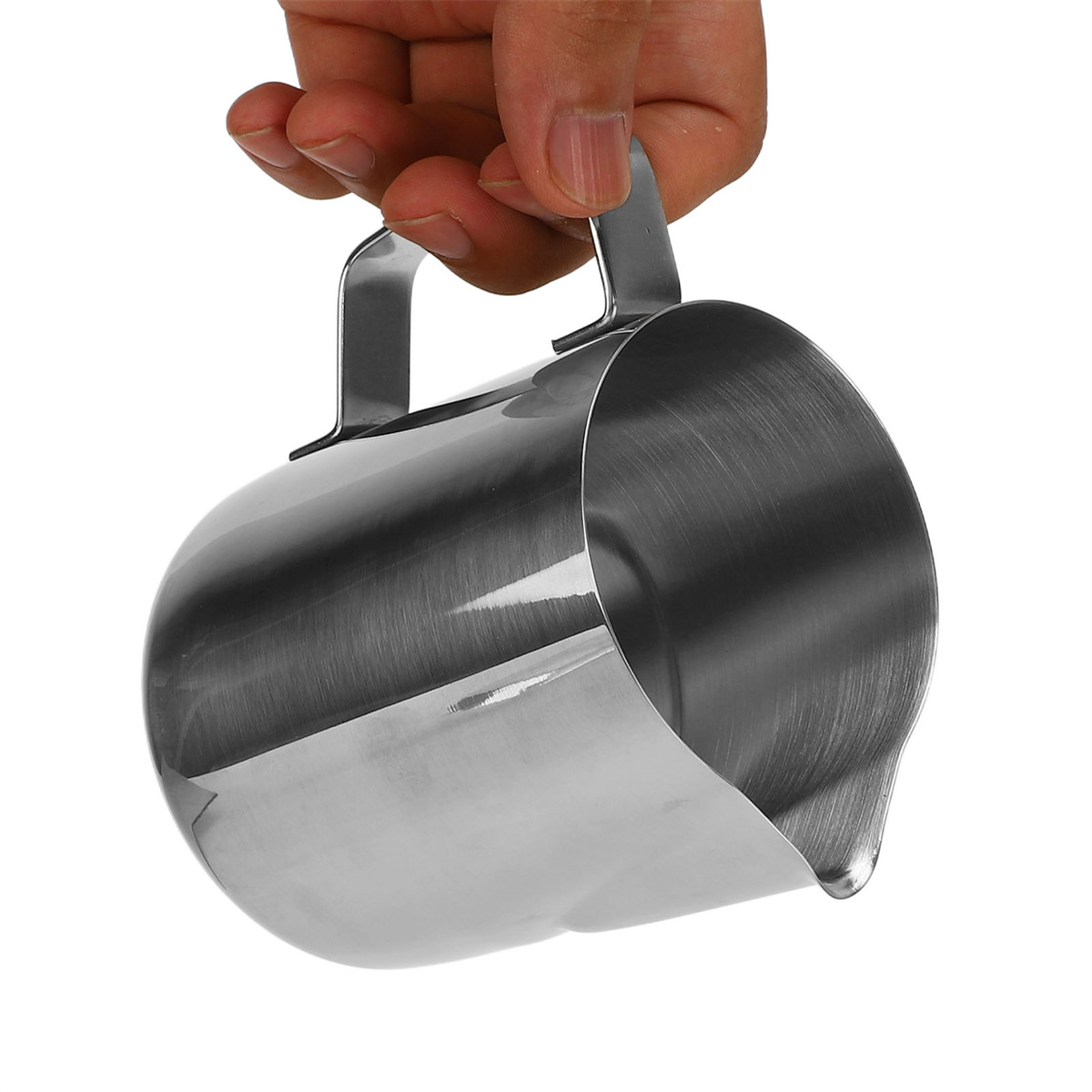 Eine Hand hält einen glänzenden Milchaufschäumkrug aus Edelstahl mit gebogenem Ausguss und Griff.
