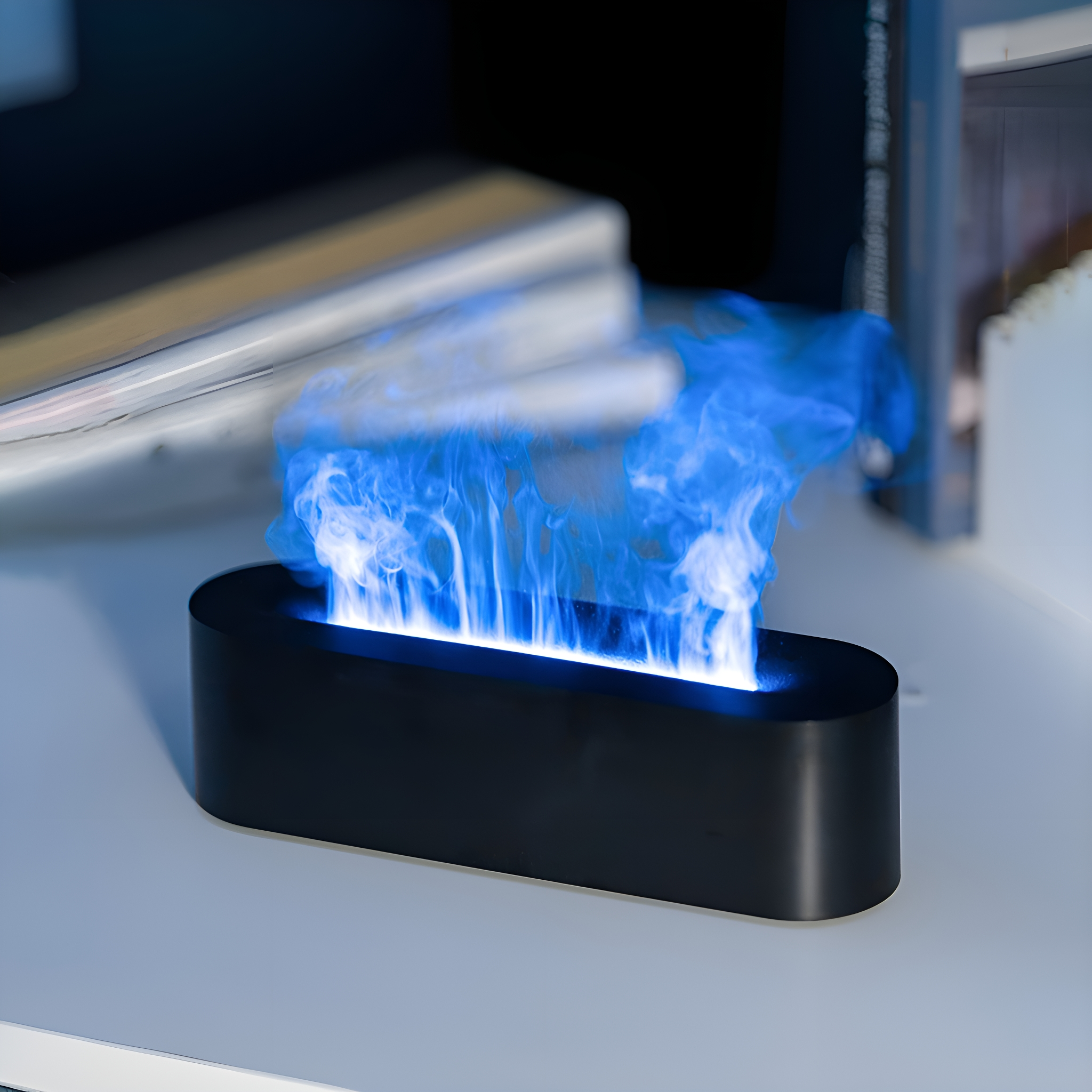 Schwarzes dekoratives Flammlicht mit blauem Licht, auf einem weißen Regal, mit Büchern im Hintergrund.