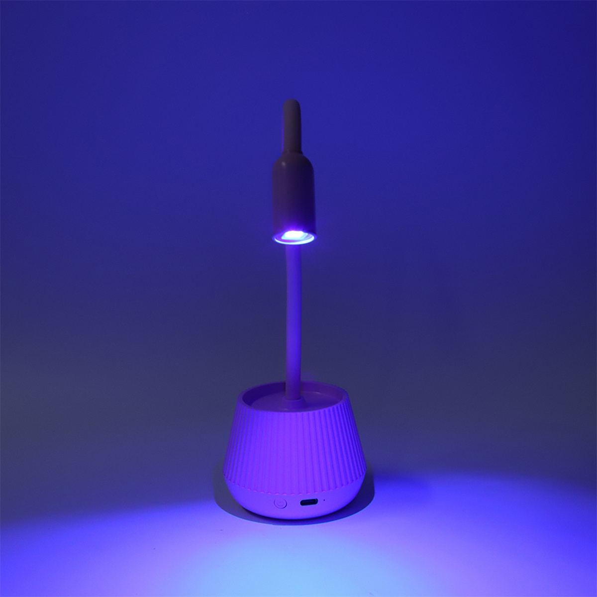 Kleine, moderne UV-Lampe. Hat einen konischen Sockel und ein schlankes, vertikales Licht.