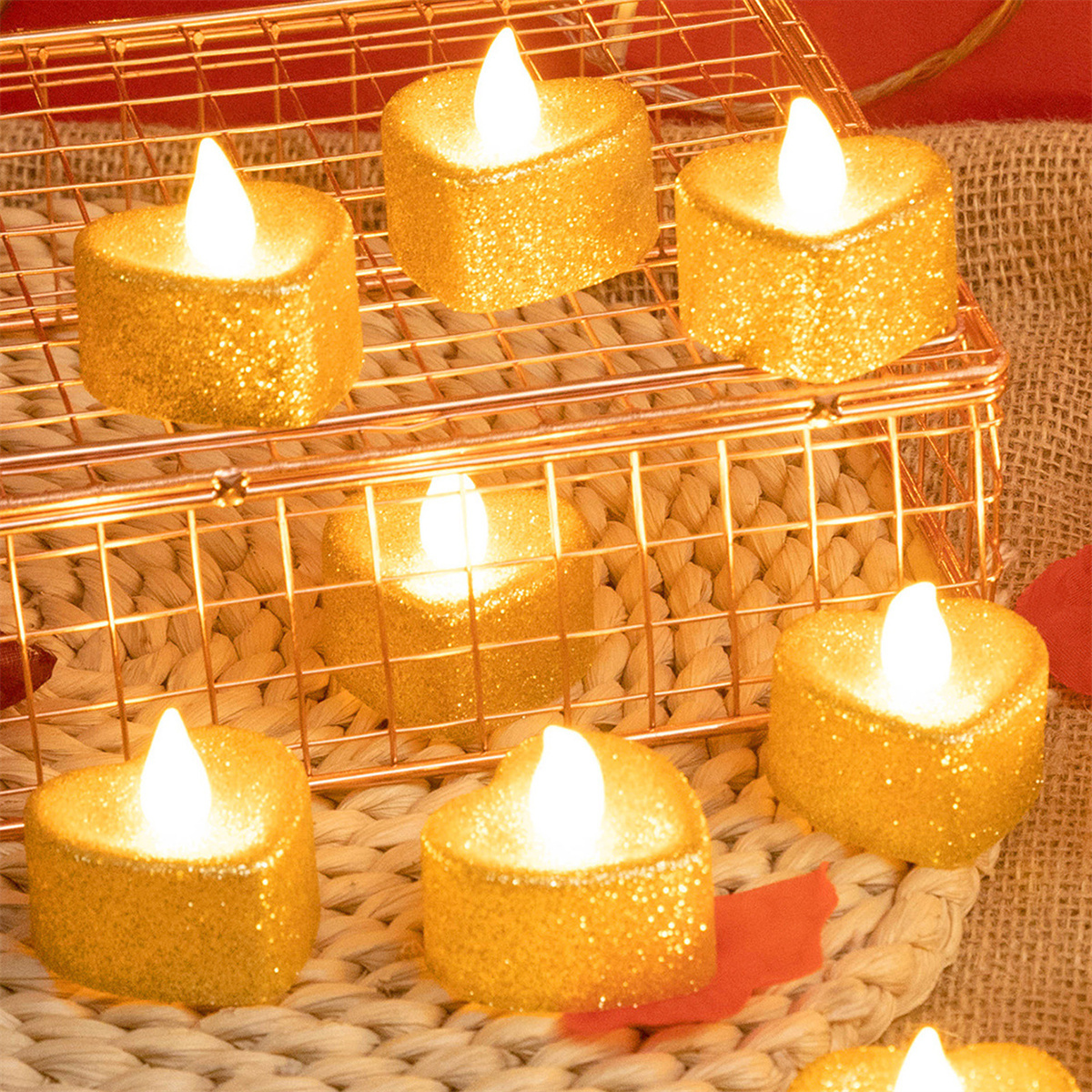 Herzförmige, glitzernde Kerzen in einem goldenen Drahtkorb, mit unscharfem Hintergrund.