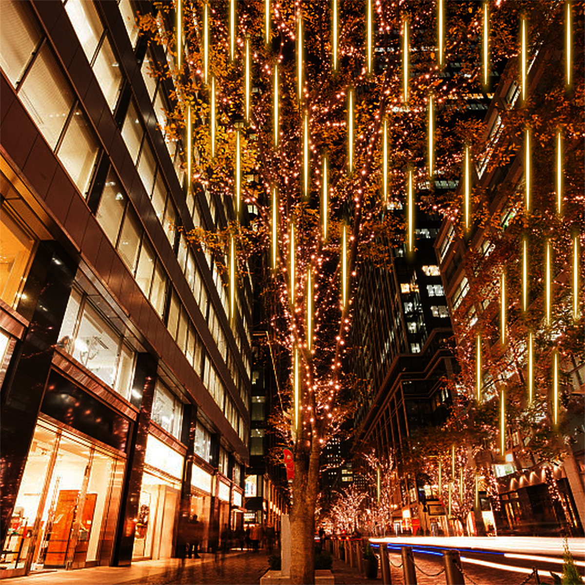 Stadtstraße bei Nacht mit einem Baum, der mit gelben Lichtern geschmückt ist.