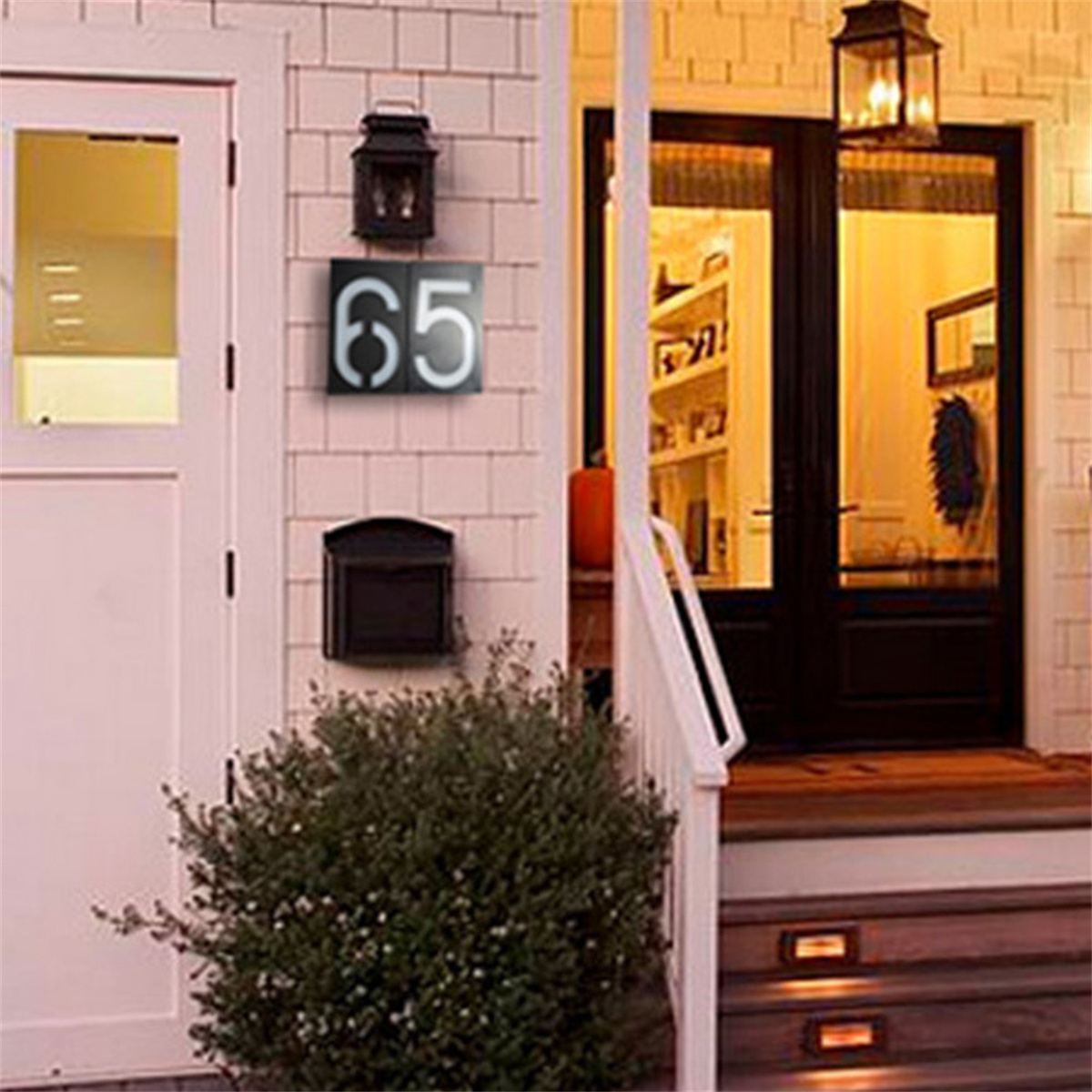 Ein Haus mit einem Nummernschild 65, einem Briefkasten und einer Haustür.