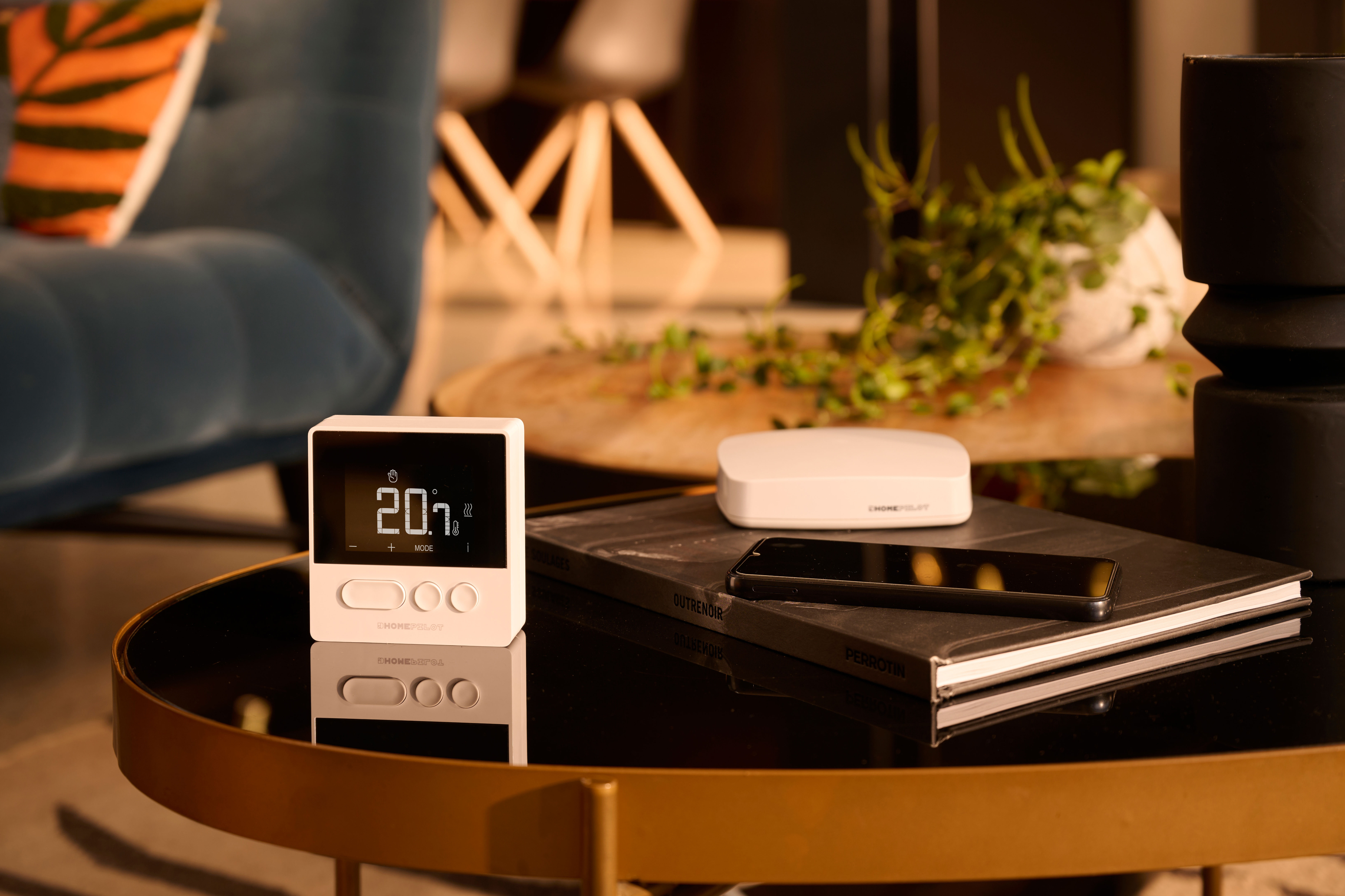 Smart Home Gerät auf einem Tisch, einschließlich Thermostat und Tablet.