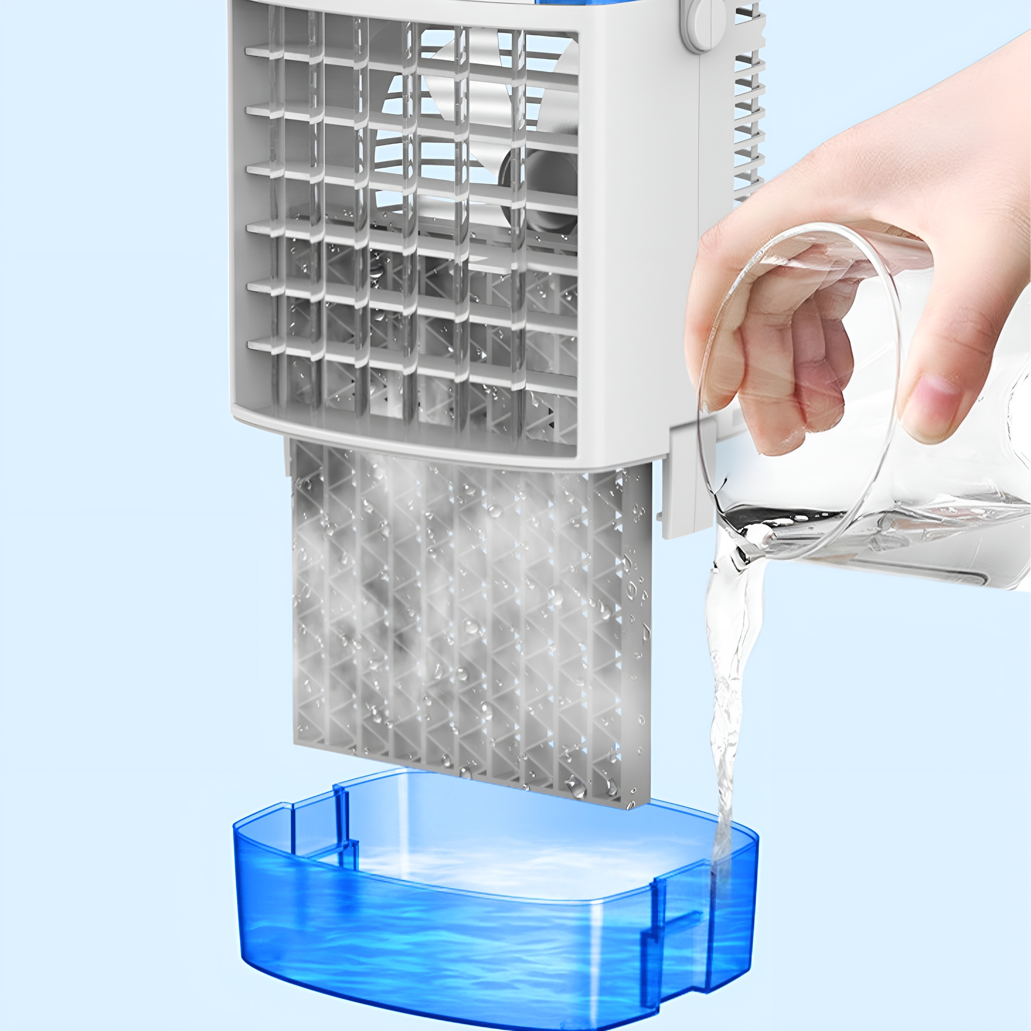 Eine Person gießt Wasser in einen blau-weißen Luftkühler, Wassertröpfchen sichtbar.