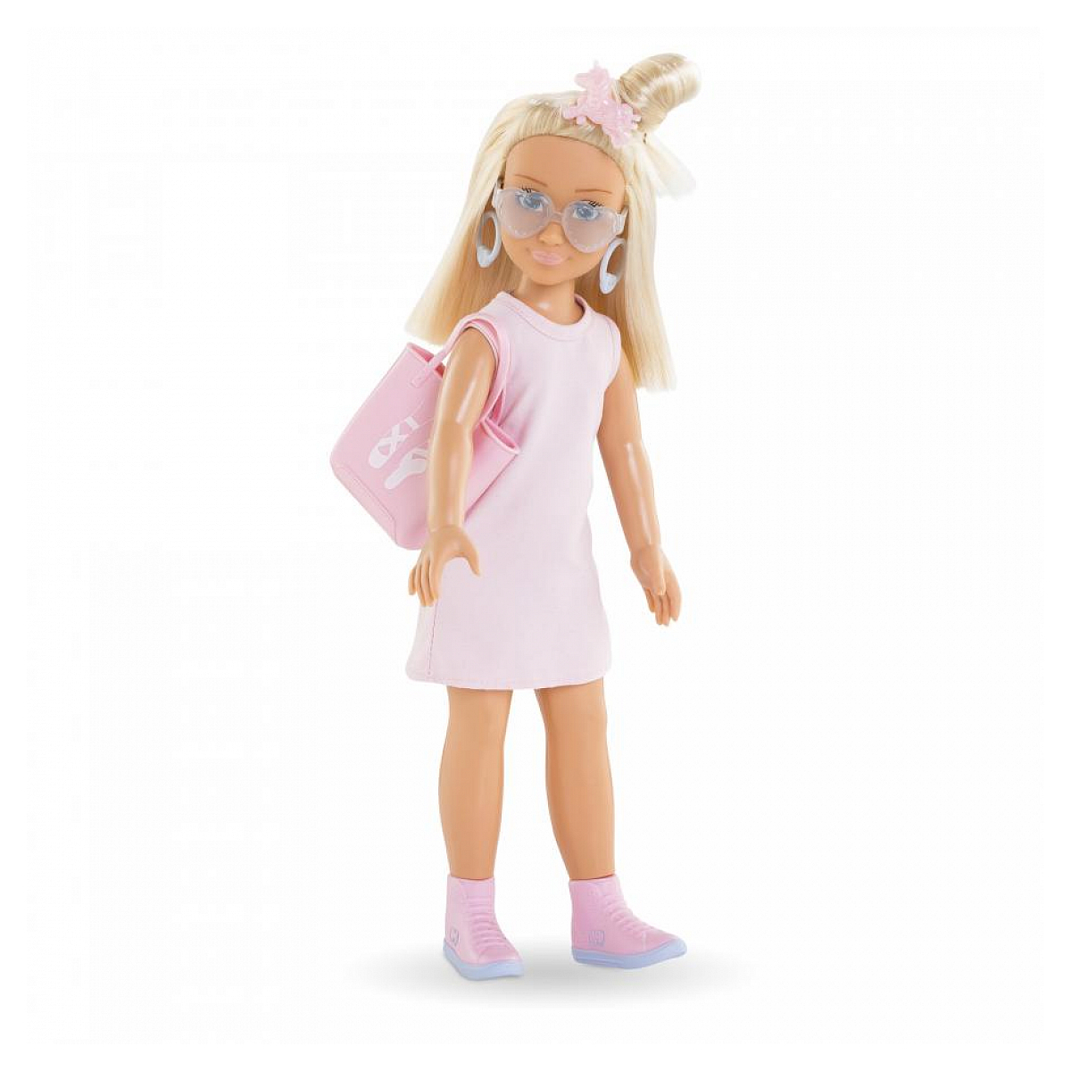 Eine Puppe in rosa Kleid, Sonnenbrille und Tasche. Sie hat blondes Haar und steht vor weißem Hintergrund.