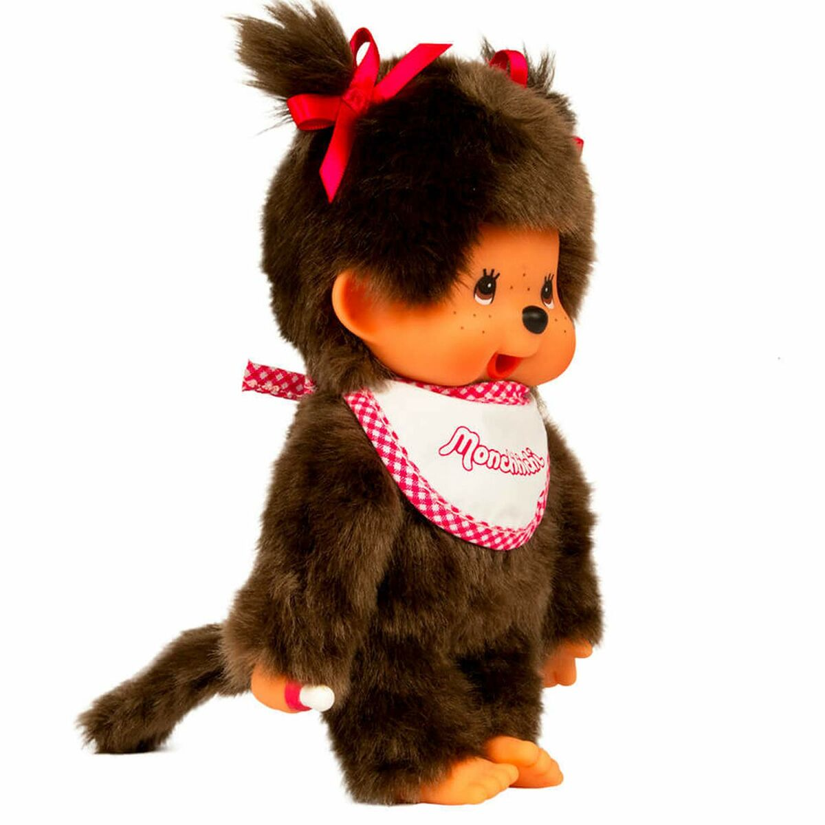 Eine braune Monchhichi-Puppe mit roter Schleife auf dem Kopf, Lätzchen und Schwanz.
