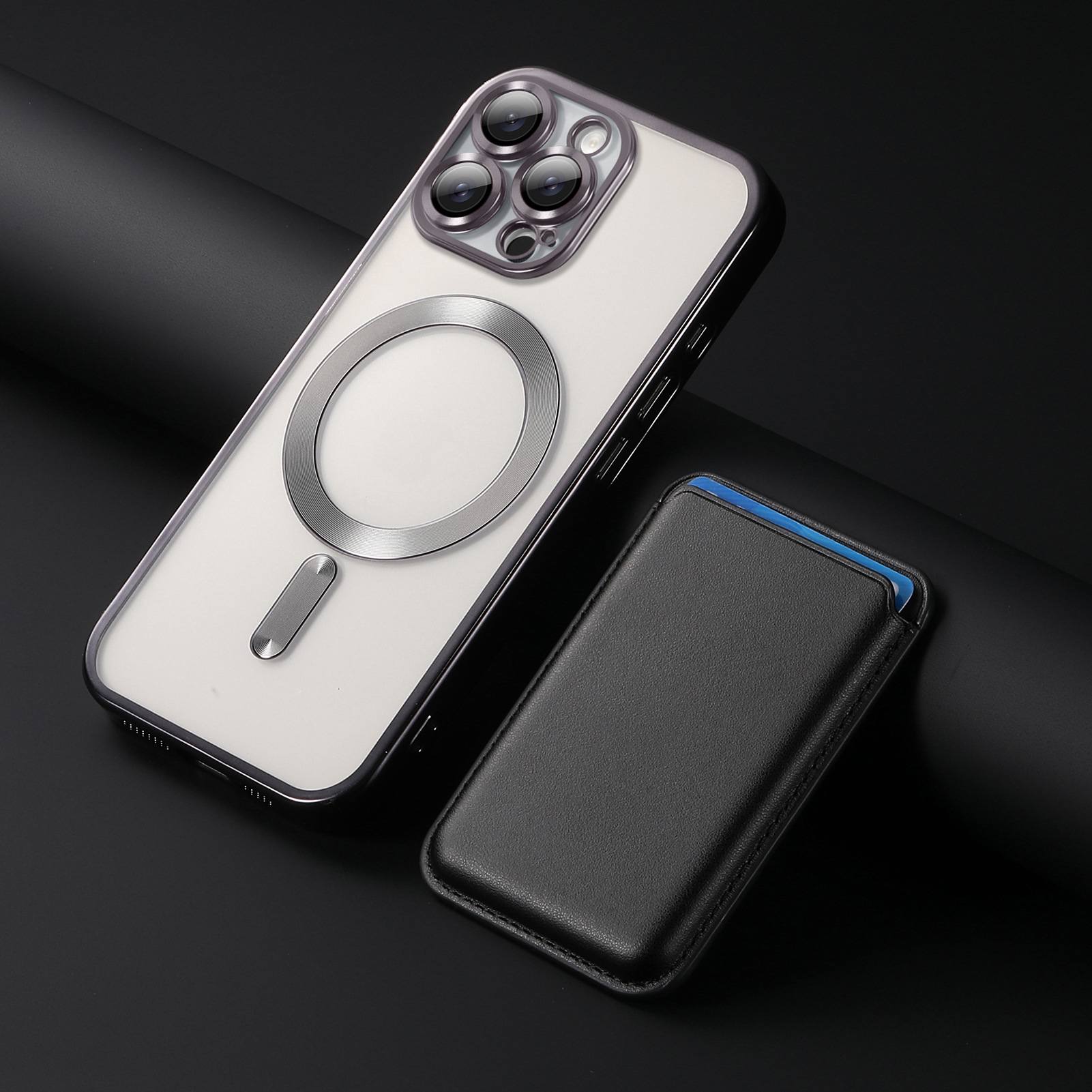 Una custodia trasparente per telefono con un anello argentato e un porta carte nero accanto su una superficie scura.