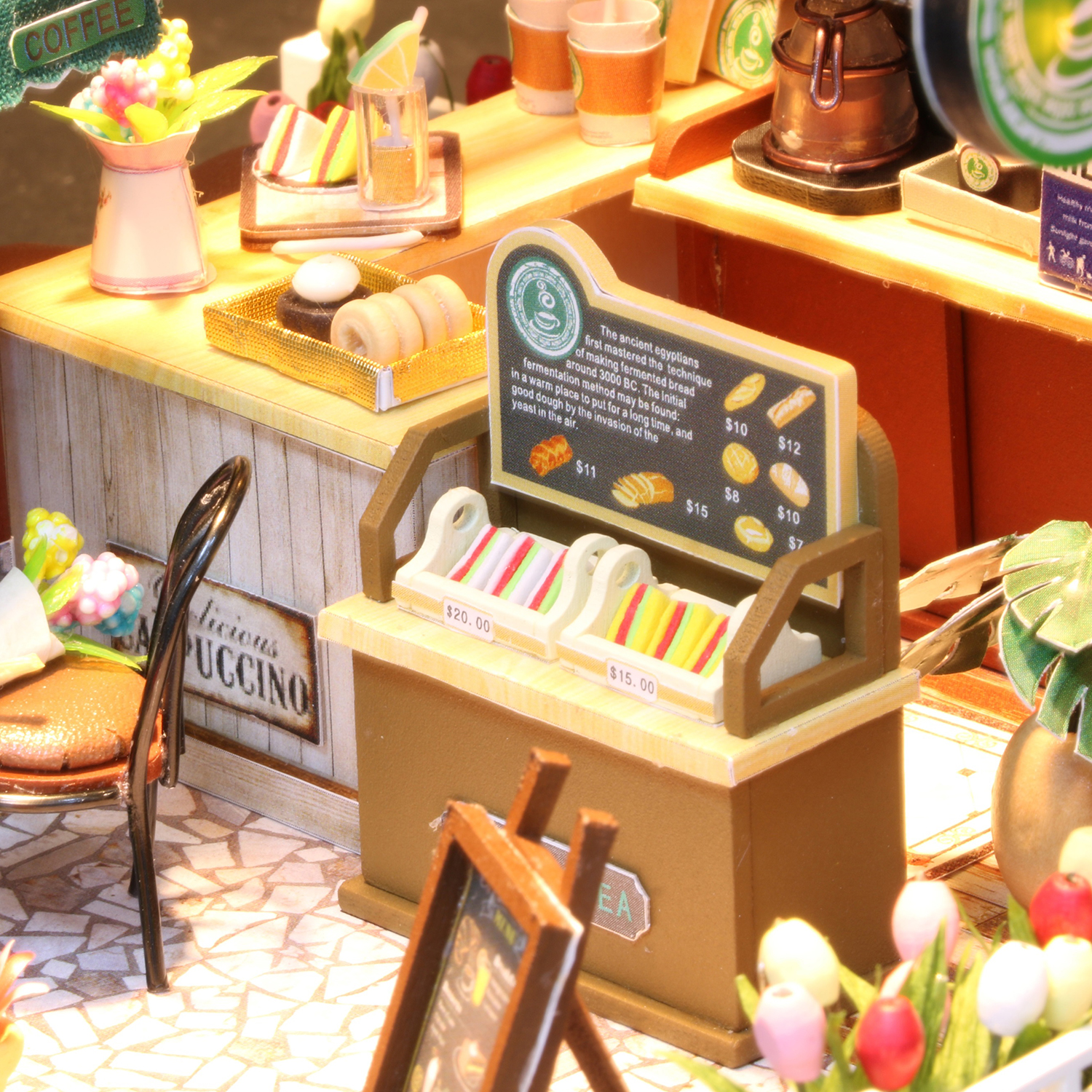 Scena di caffè in miniatura con esposizione di cibo, posti a sedere e lavagna del menu. Focus sul bancone.