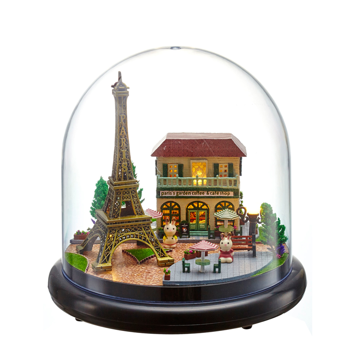 Miniatura della Torre Eiffel e caffè in una cupola di vetro, con conigli e alberi.