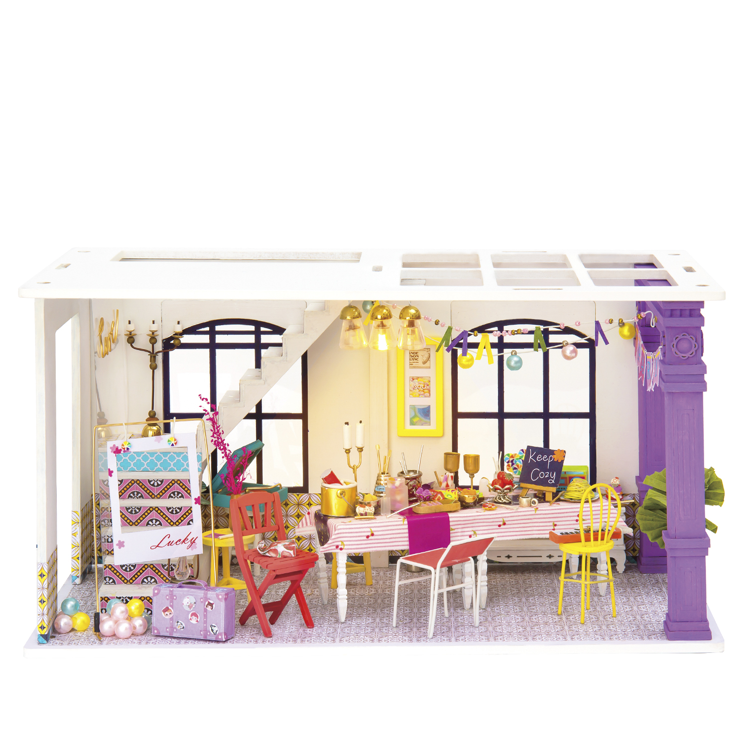 Interno di casa delle bambole con tavolo per una festa. Diversi oggetti in miniatura.