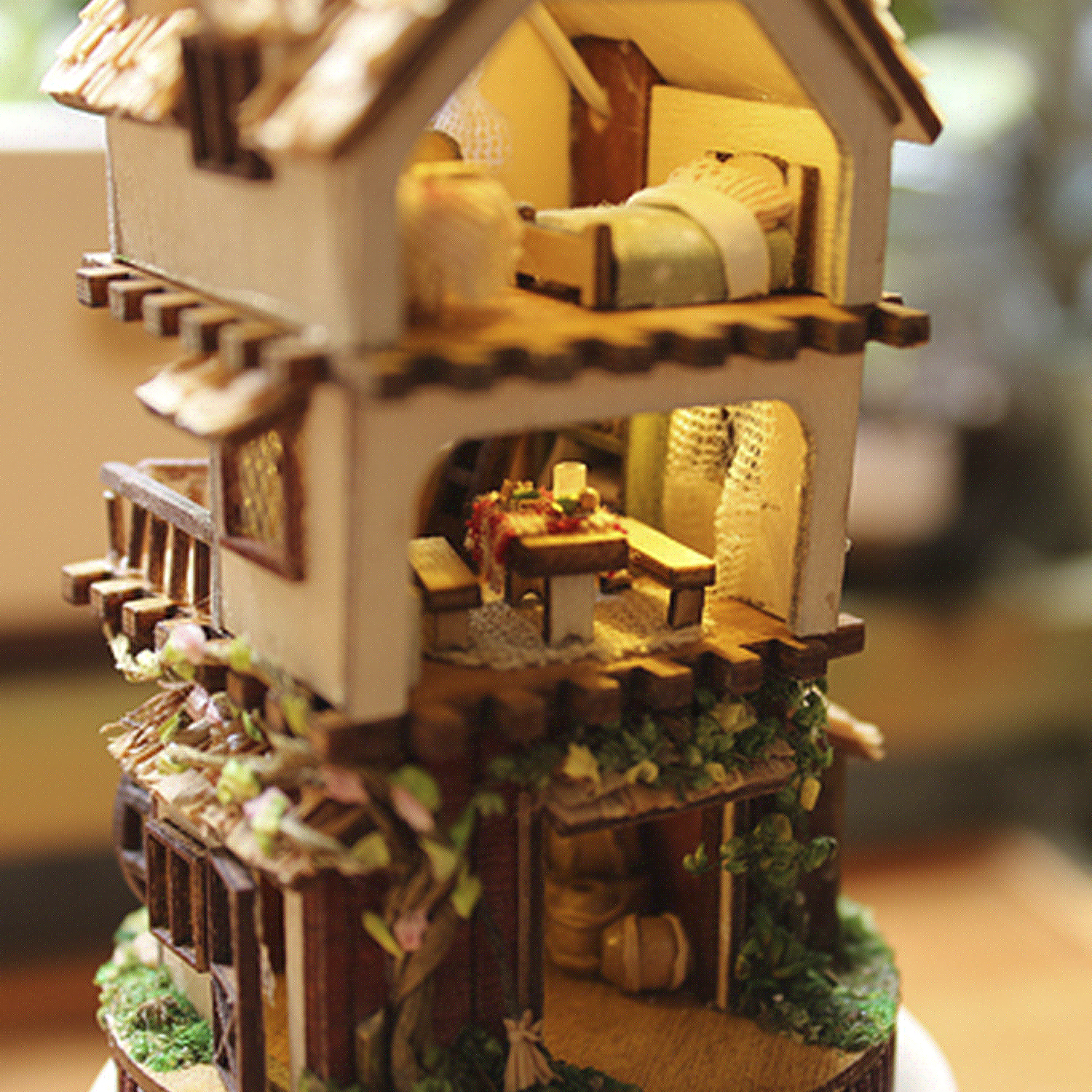 Interno di casa in legno in miniatura con letto, tavolo ed elementi decorativi.