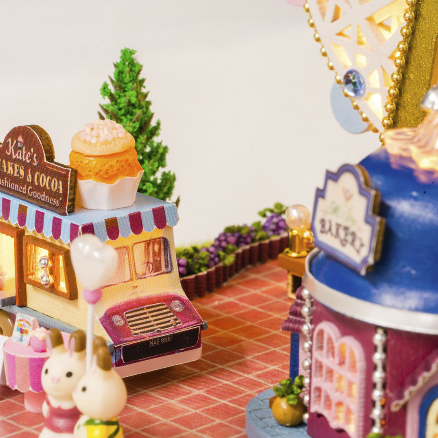 Pasticceria in miniatura con cupcakes e un food truck, un'insegna che dice 'Kate's Cakes & Cocoa'.