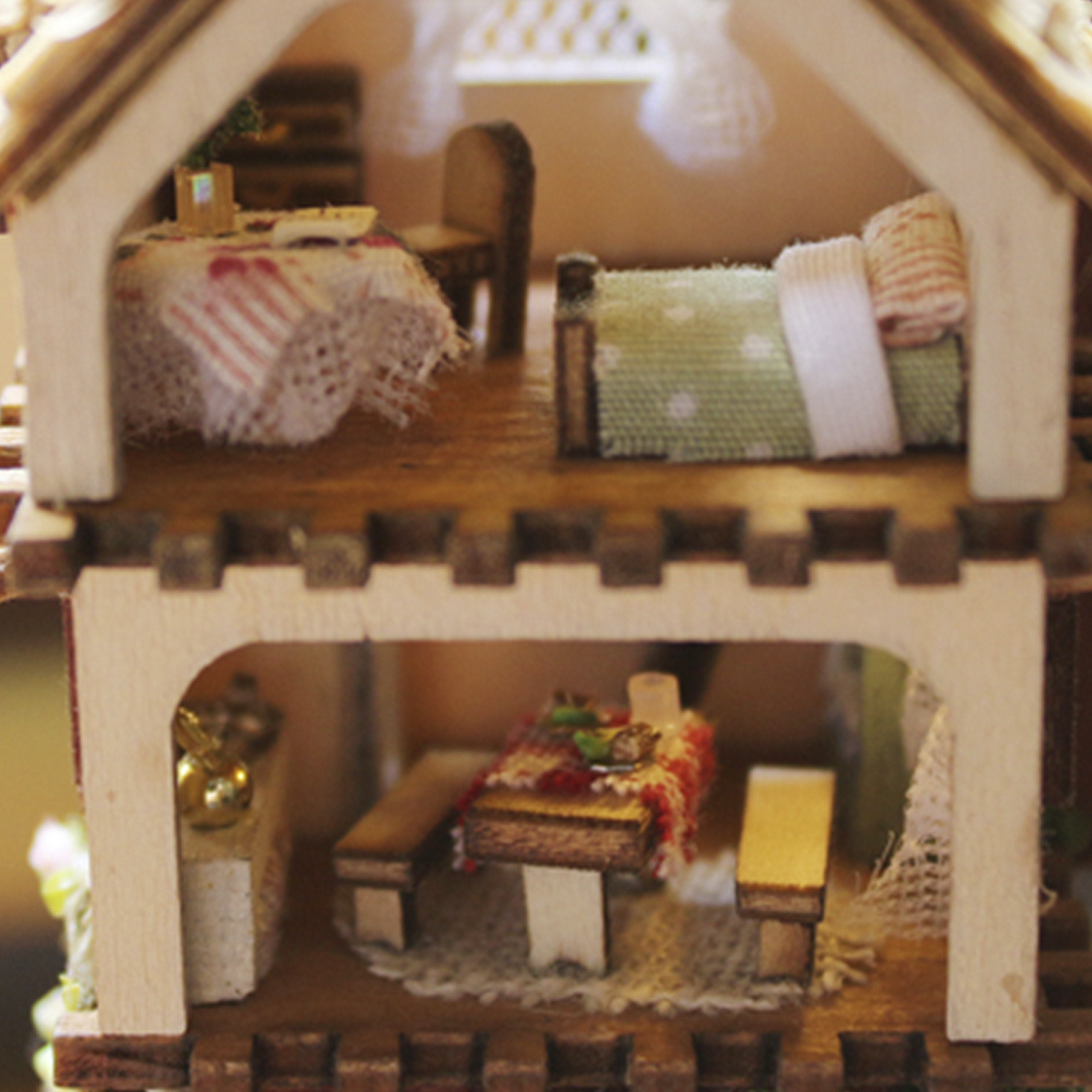 Un interno di casa in miniatura con due piani. Include una sala da pranzo e una camera da letto. Struttura in legno.