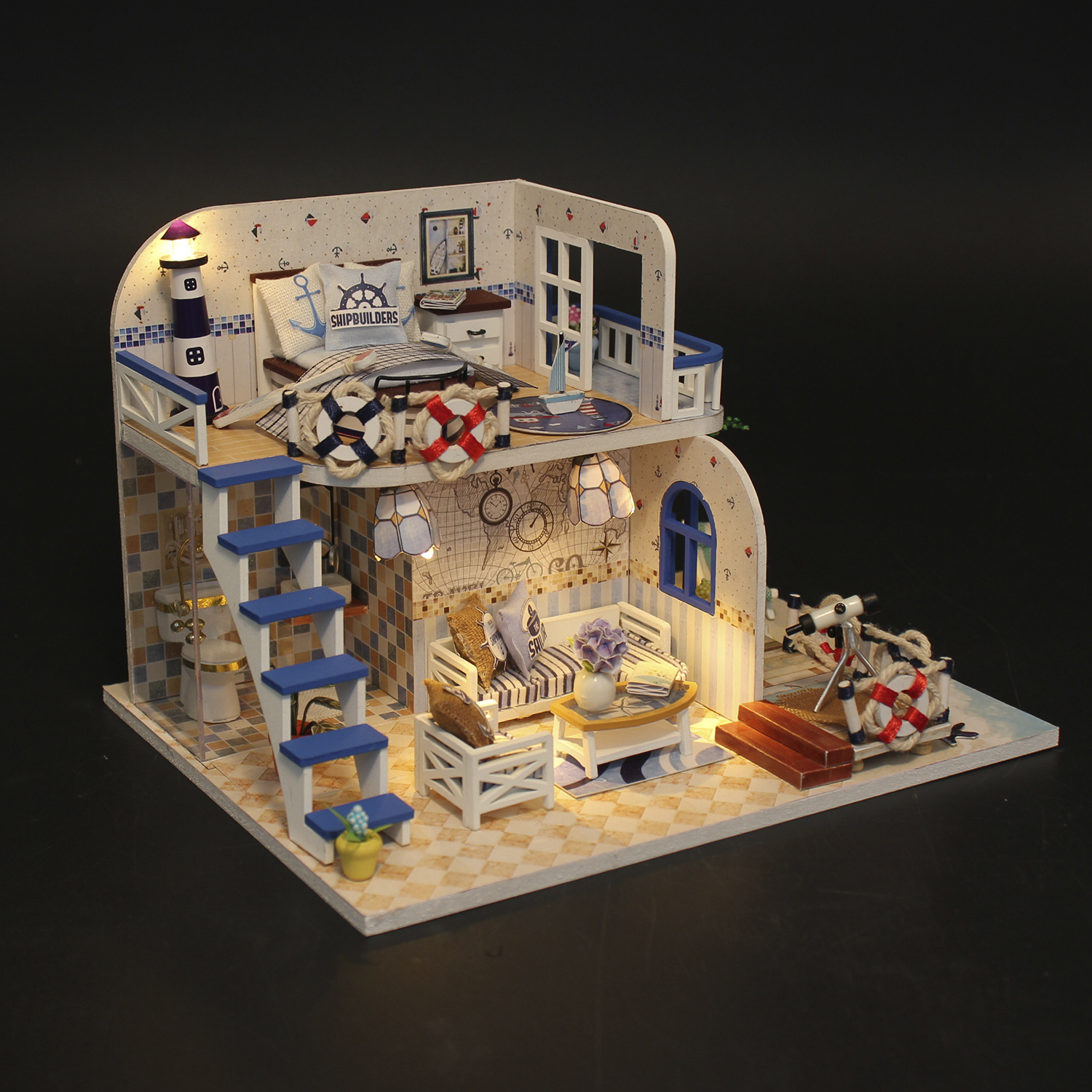 Una casa delle bambole in miniatura a tema nautico, con una struttura a due piani, scale blu e decorazioni.