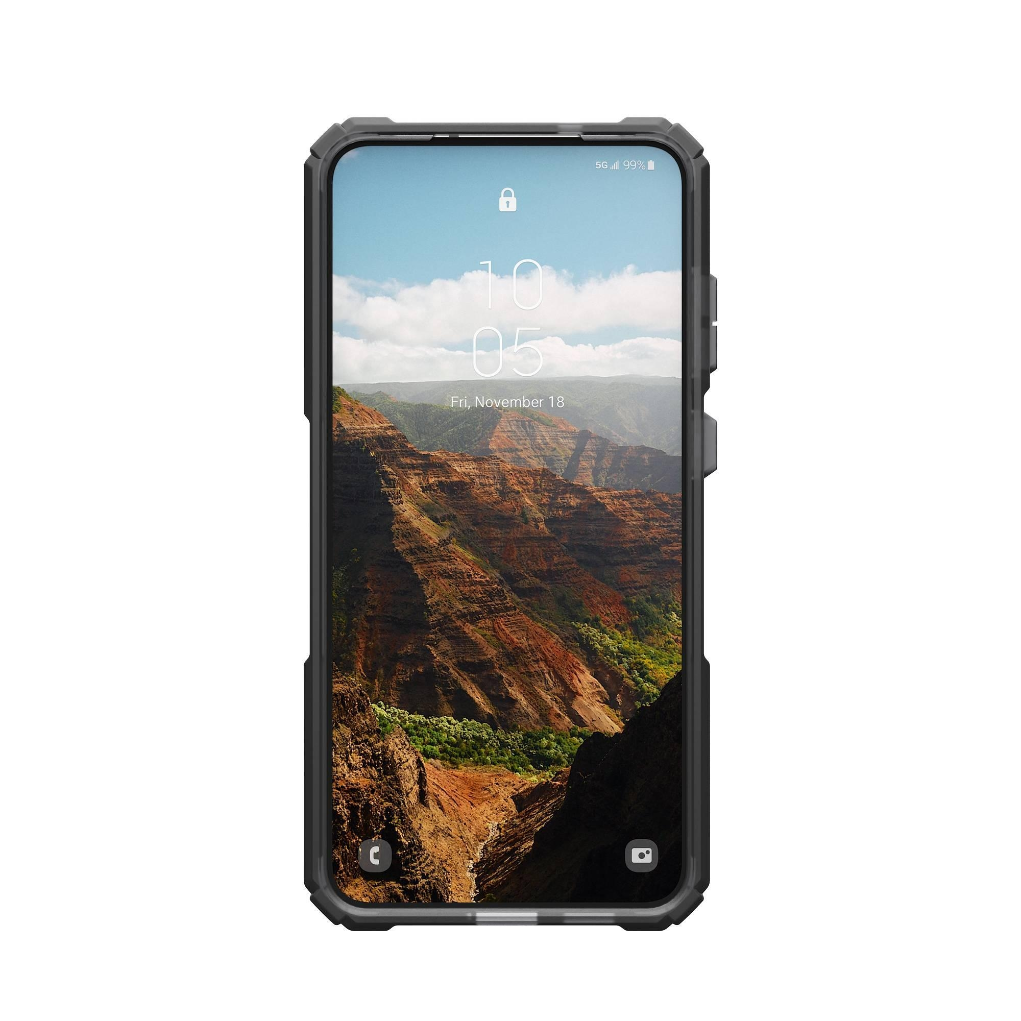 Telefono nero in custodia robusta mostra un paesaggio di canyon, con data e ora sovrapposte.