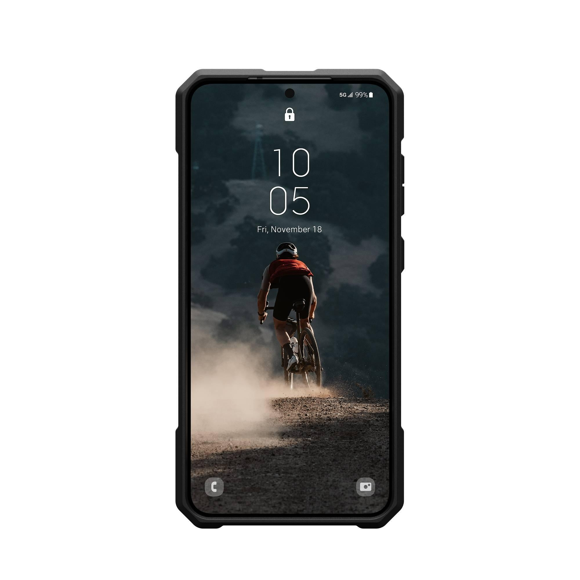 Un telefono in una custodia nera. Lo schermo mostra un ciclista su una strada polverosa.