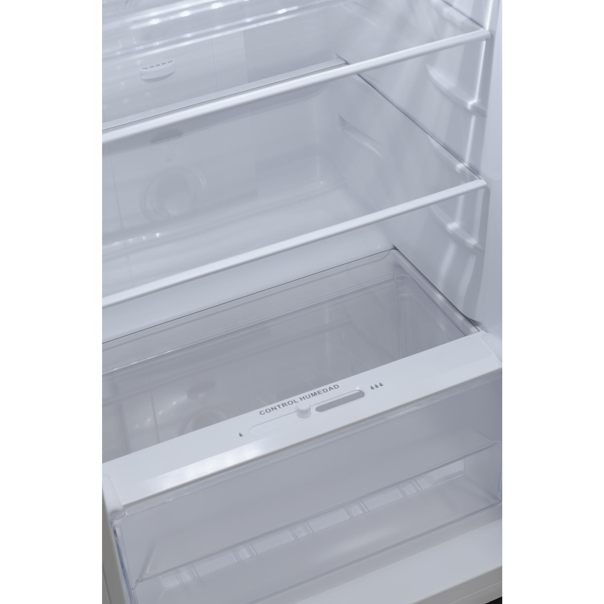 Interior de un refrigerador blanco con estantes y cajón para verduras, bien iluminado, limpio.
