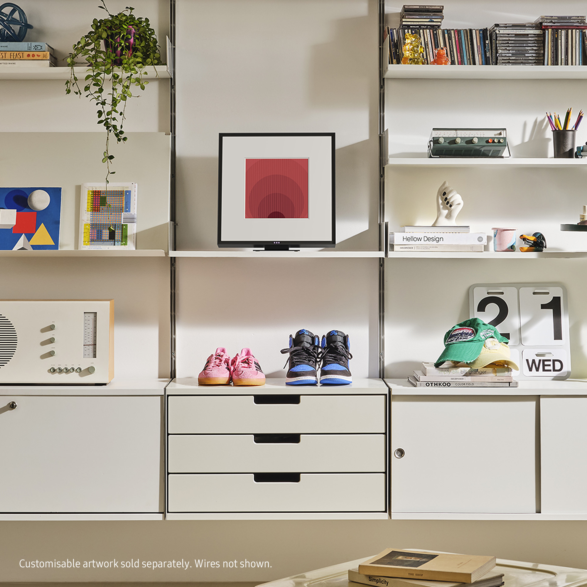 Półka z dziełami sztuki, książkami, butami i radiem, wszystko na białym tle.