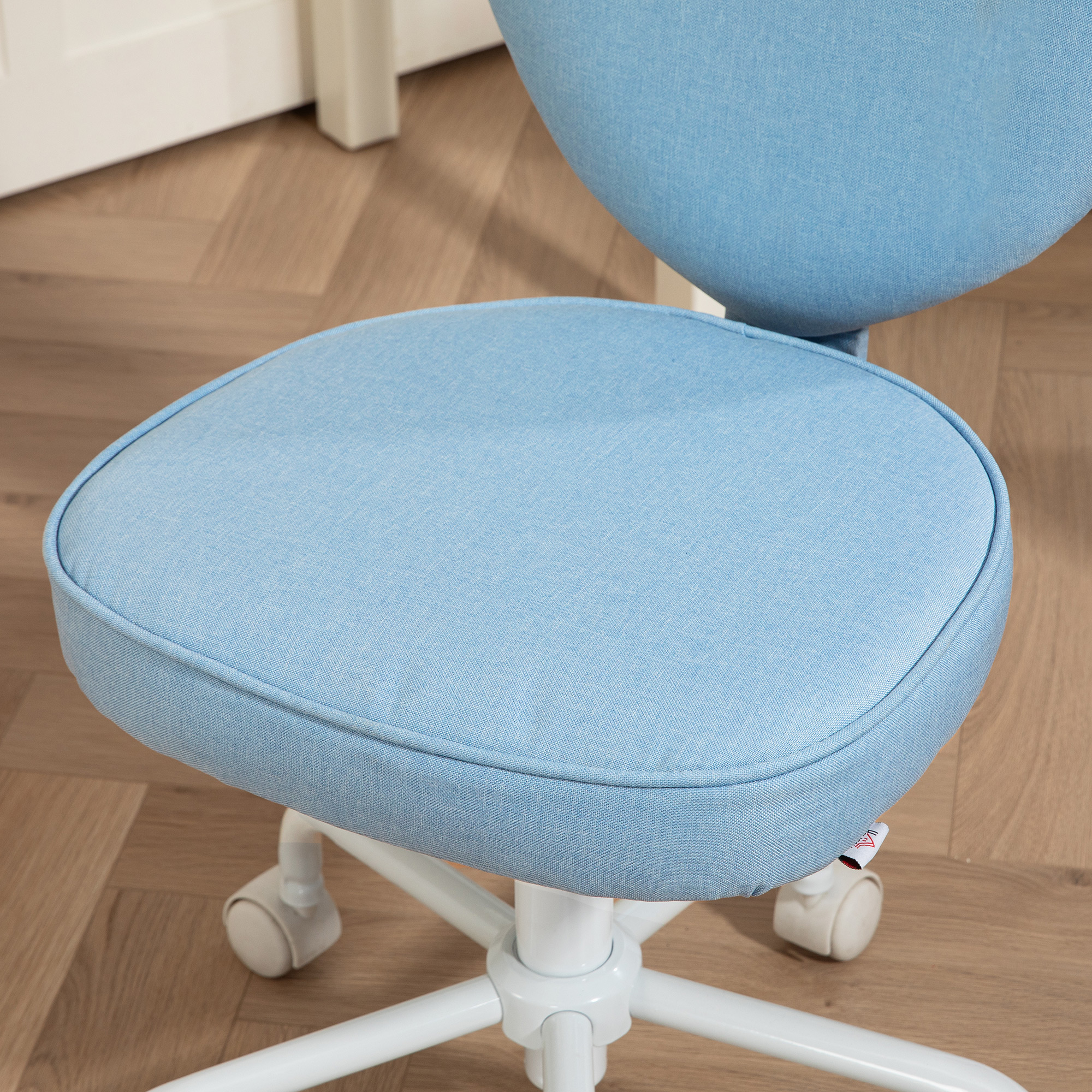 Sedile blu per sedia da ufficio con ruote bianche, su un pavimento in legno chiaro.