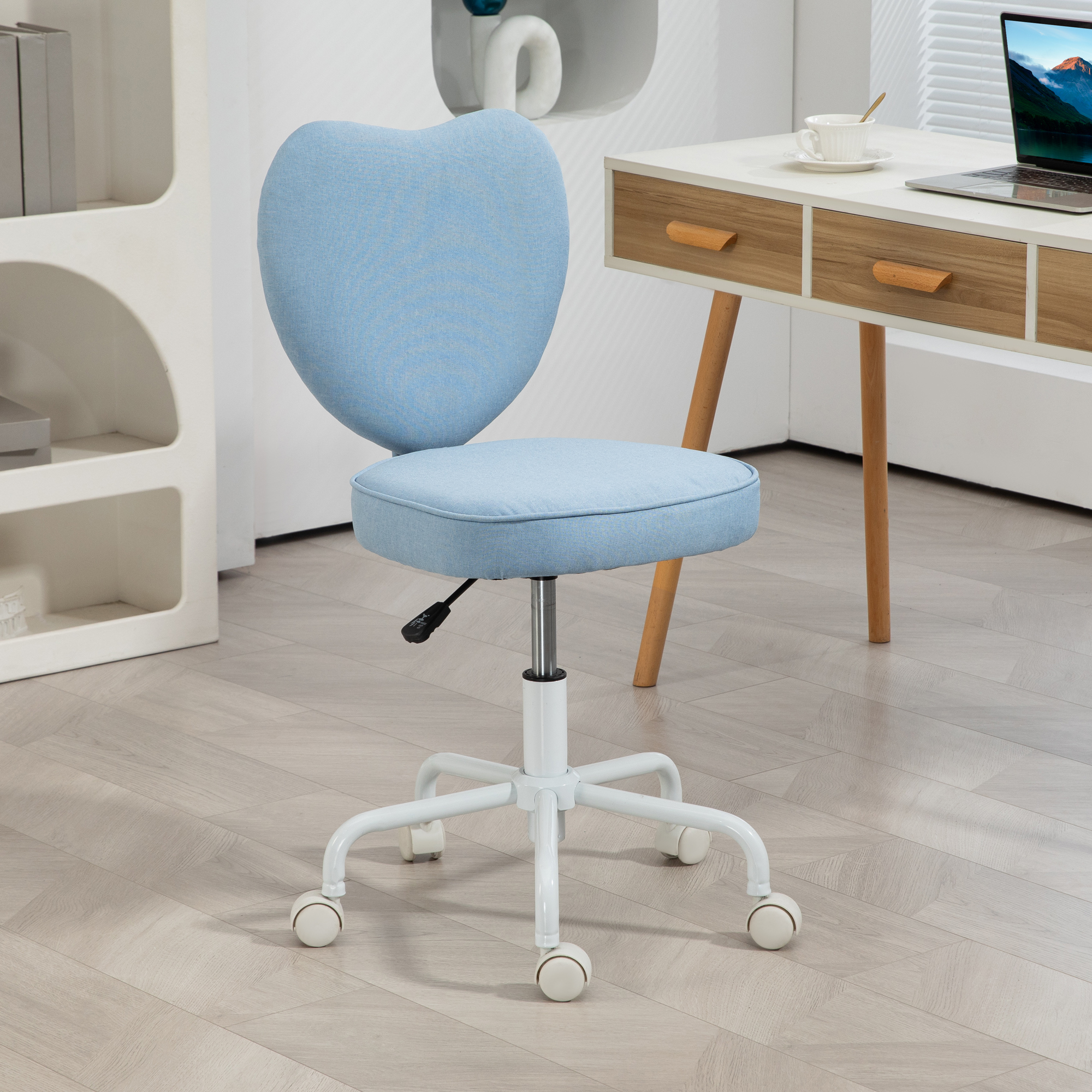 Sedia blu a forma di cuore in una stanza con una scrivania. La sedia ha una base bianca.