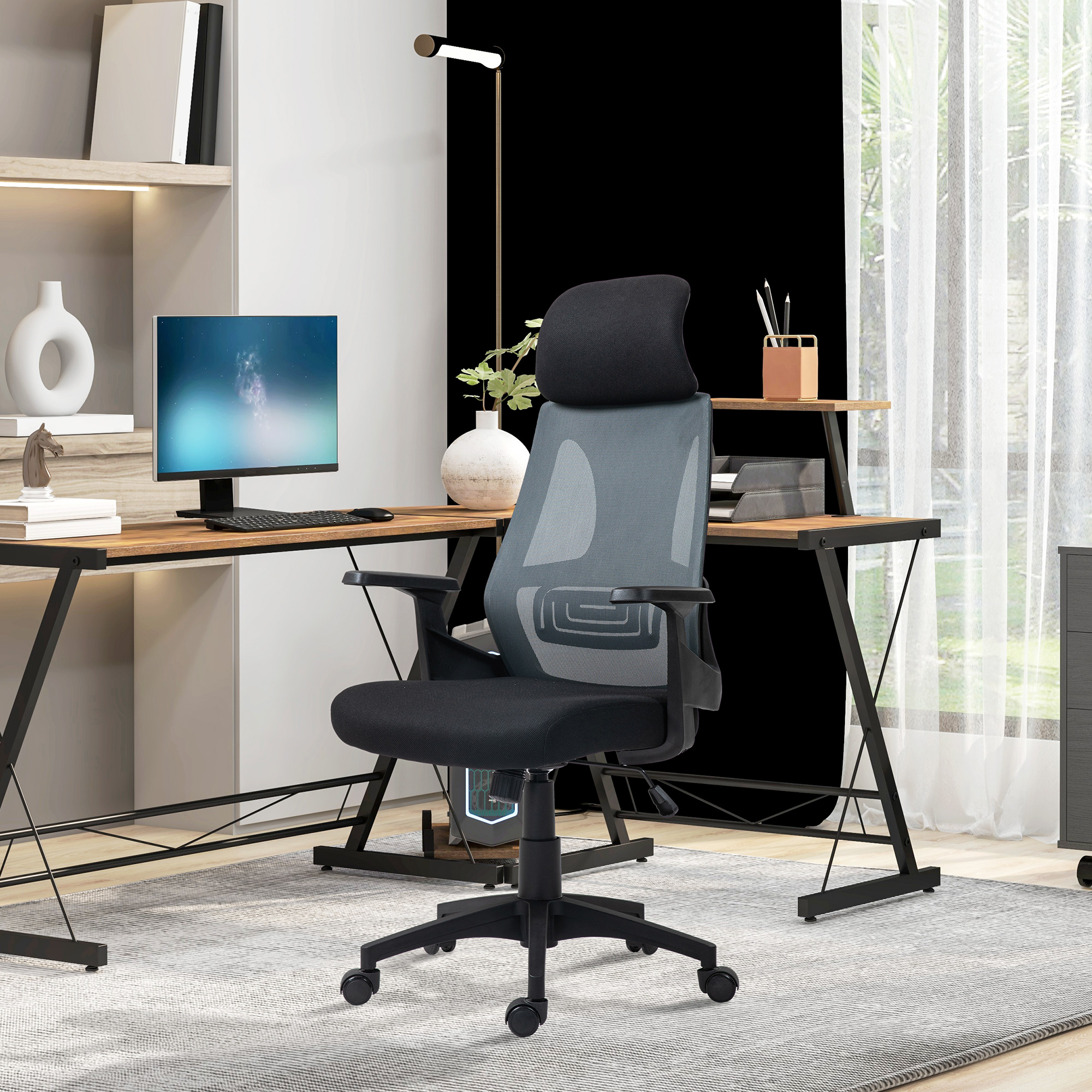 Sedia da ufficio nera con schienale in rete, scrivania nera e monitor in ufficio moderno.