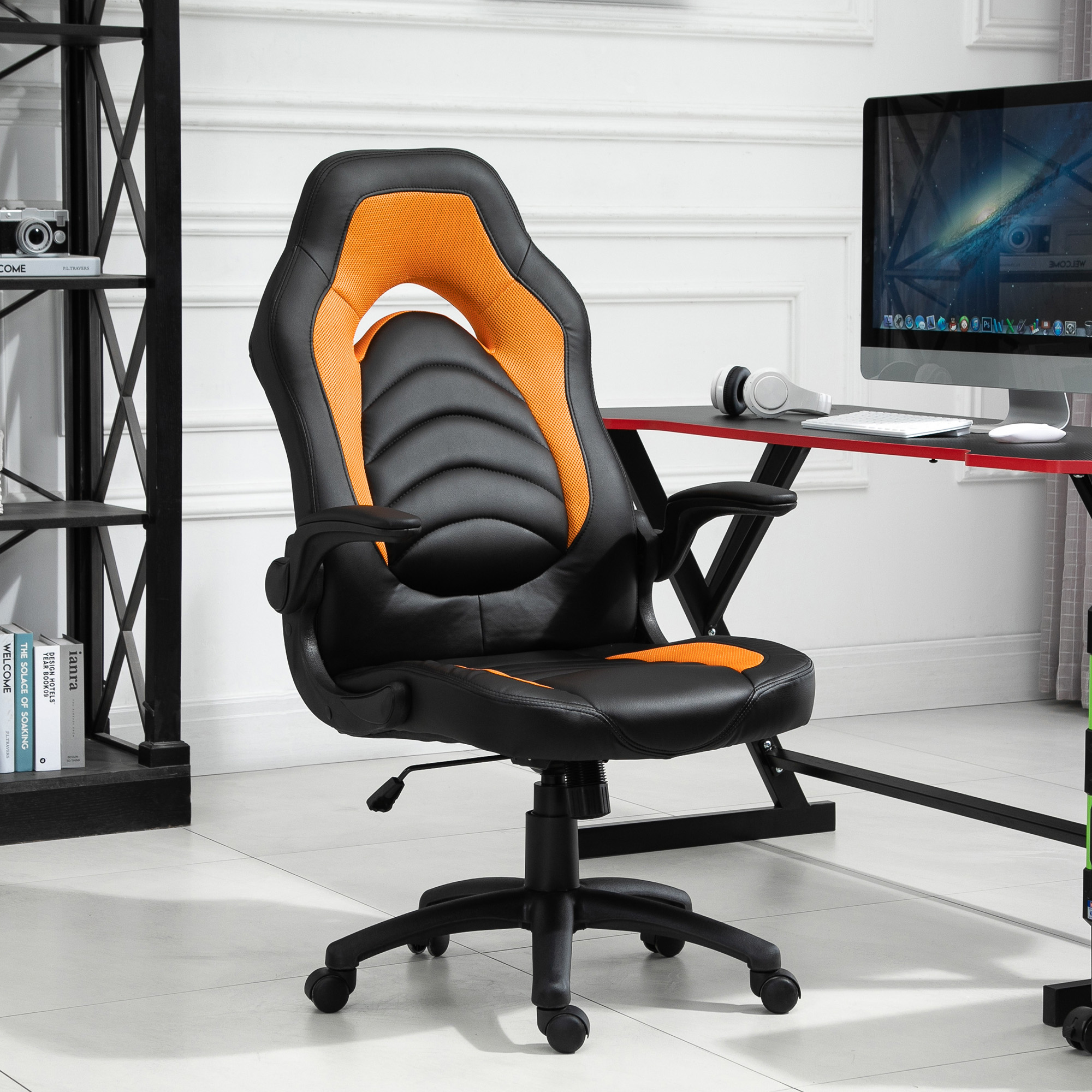 Sedia da gaming nera e arancione con parete bianca sullo sfondo. Scrivania e computer visibili.