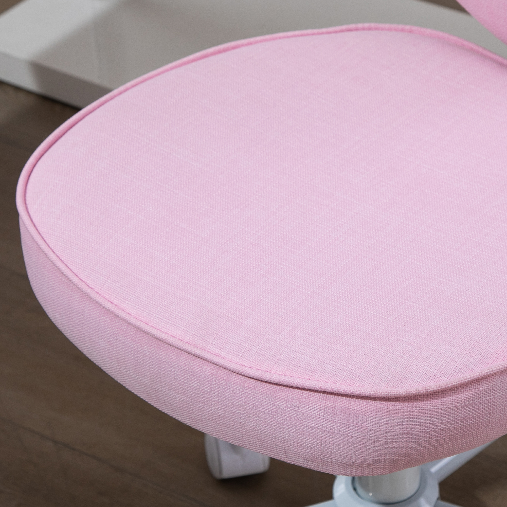 Primo piano di un sedile rosa per sedia. È rotondo e in tessuto.
