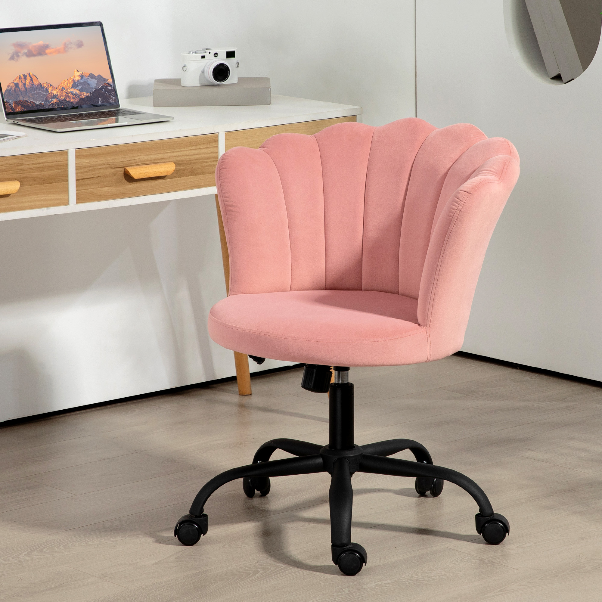 Sedia da ufficio rosa a forma di conchiglia in velluto su base nera vicino a scrivania bianca.