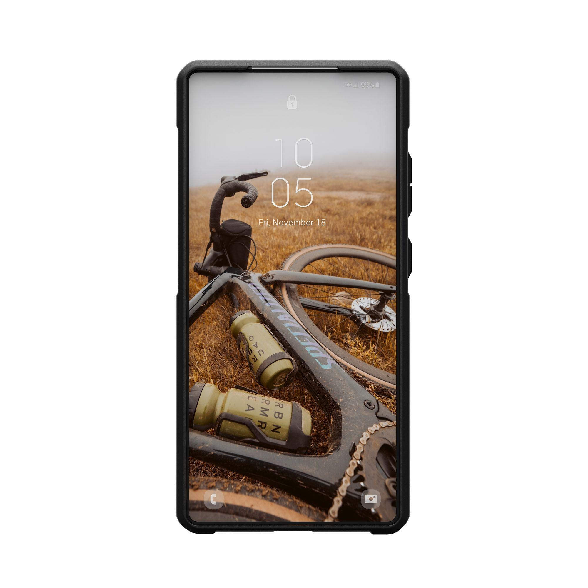 Schwarze Handyhülle mit einem Telefon, das ein Fahrrad auf Gras zeigt. Weißer Hintergrund.