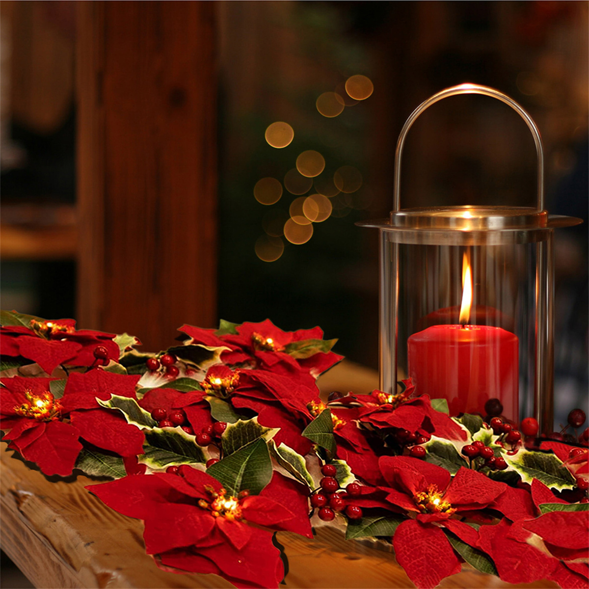 Rote Kerze in einer Glaslaterne mit roten Weihnachtssternen.