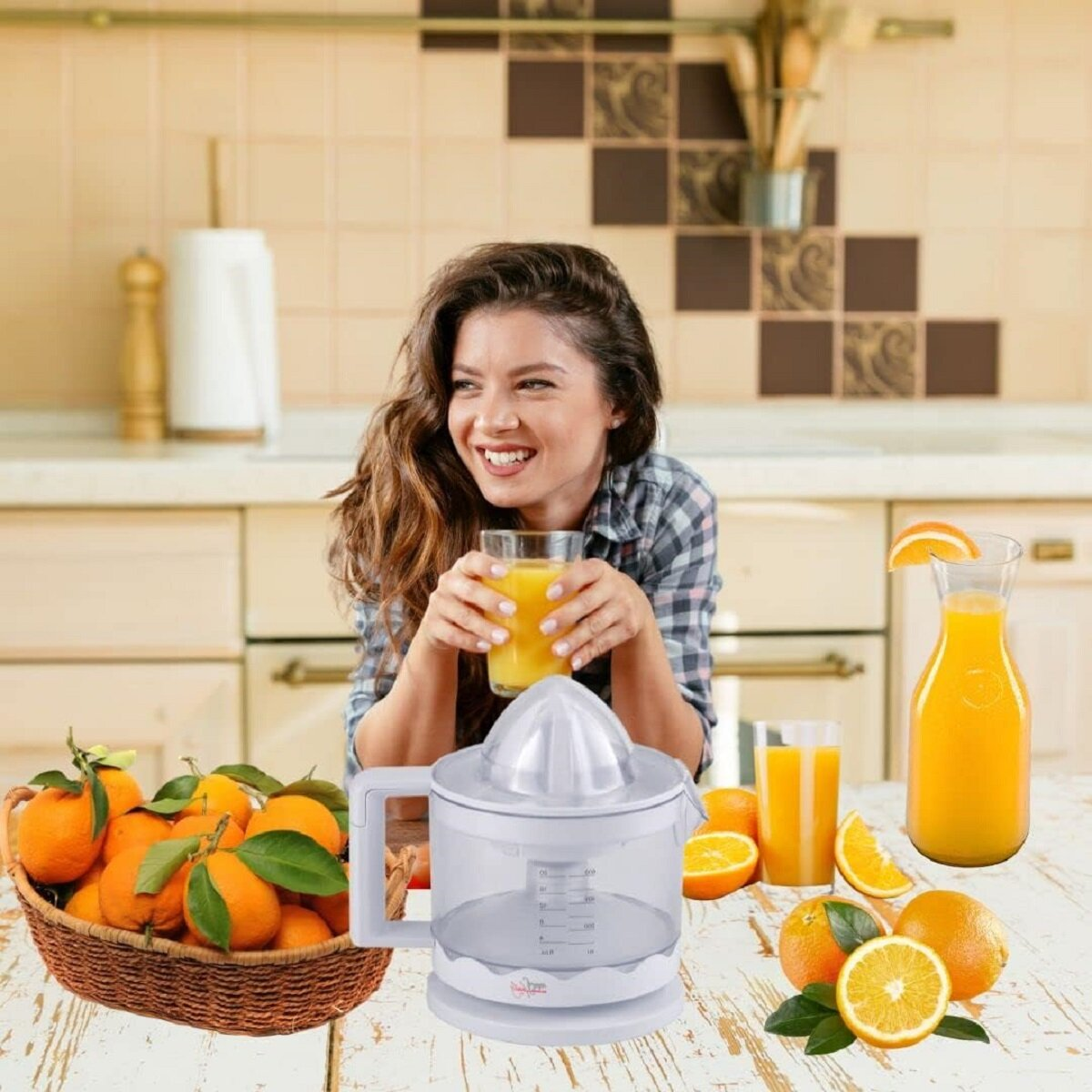 Frau mit Saft, Orangen im Korb, Entsafter auf dem Tisch, Küchenhintergrund.
