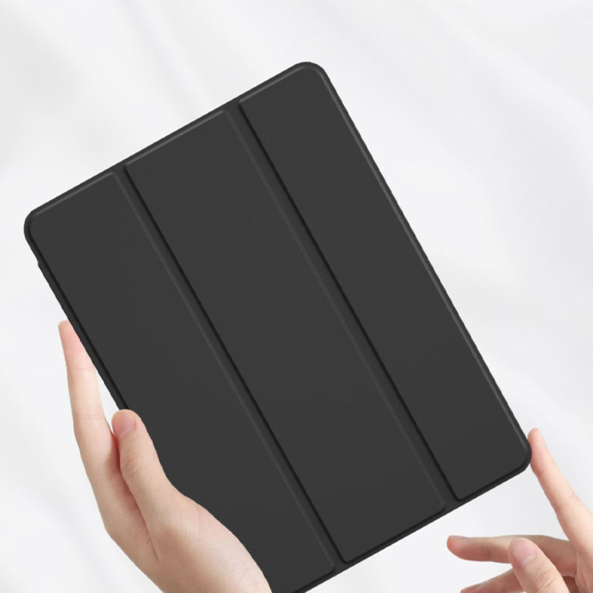 Schwarze Tablet-Hülle, gehalten von Händen, weißer Hintergrund.