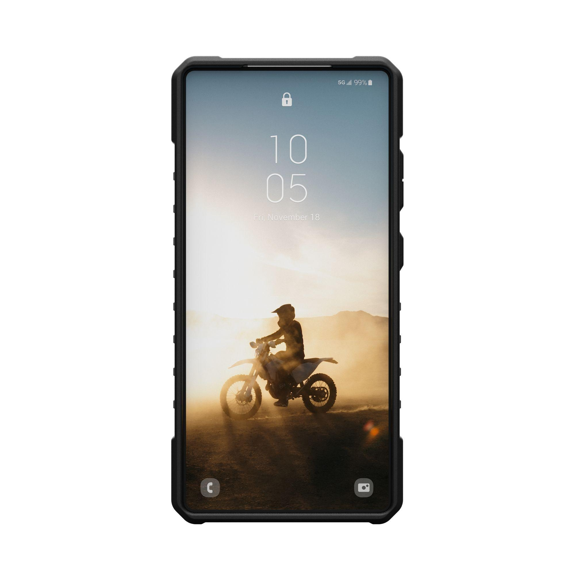 Een telefoon in een zwarte hoes toont een motorrijder tegen een zonsondergang.