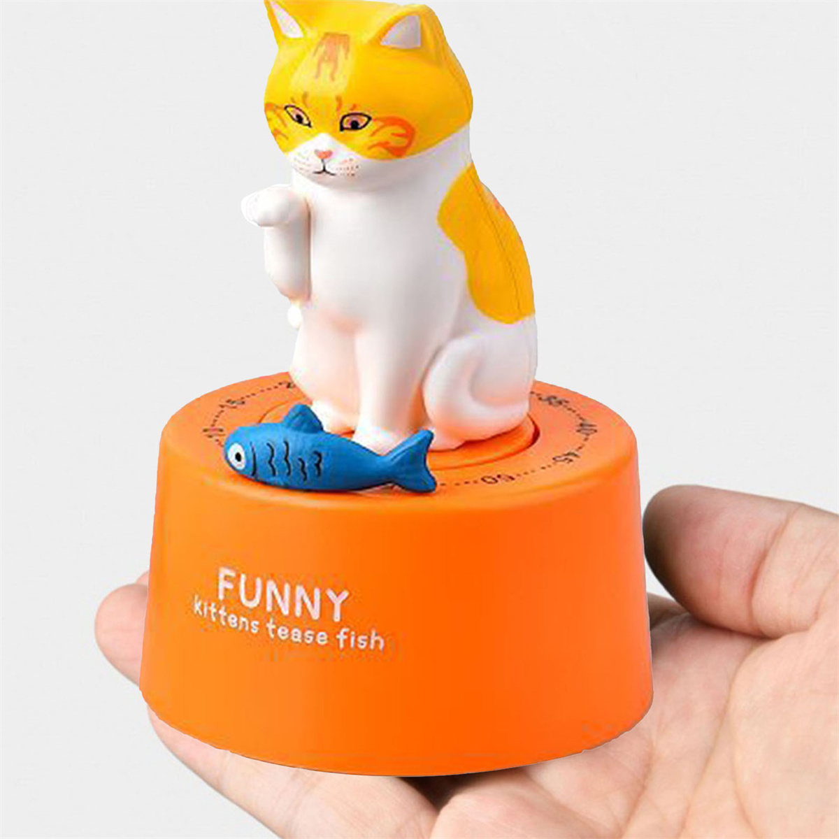 Ein katzenförmiger Küchentimer mit einem Fisch darauf.