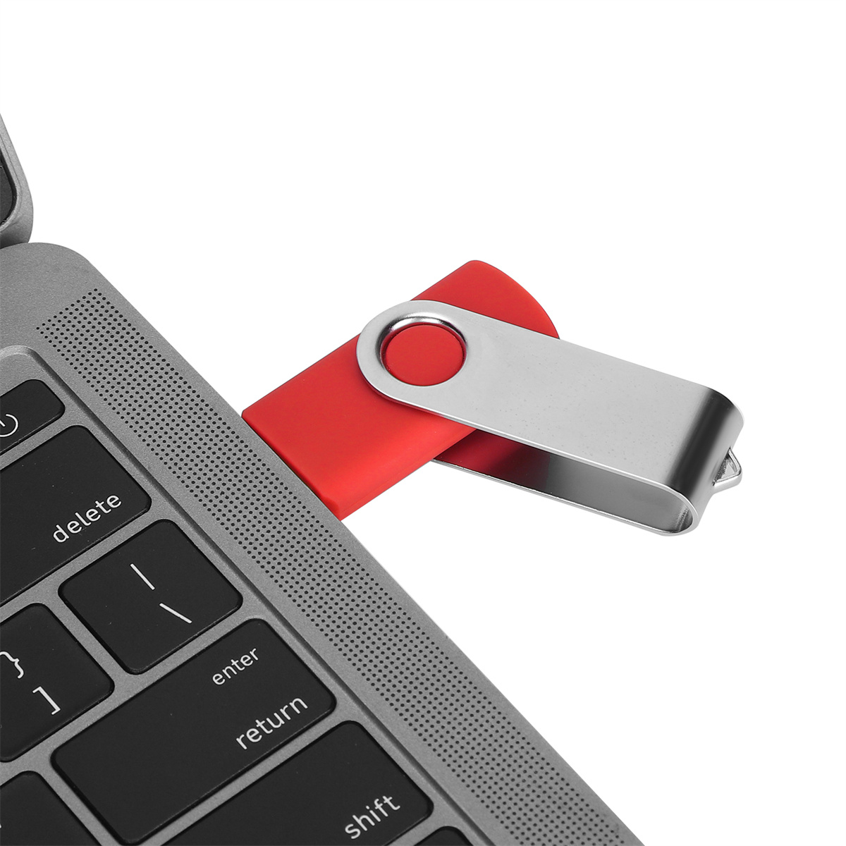 Ein roter und silberner USB-Stick, der in einen Laptop gesteckt ist.