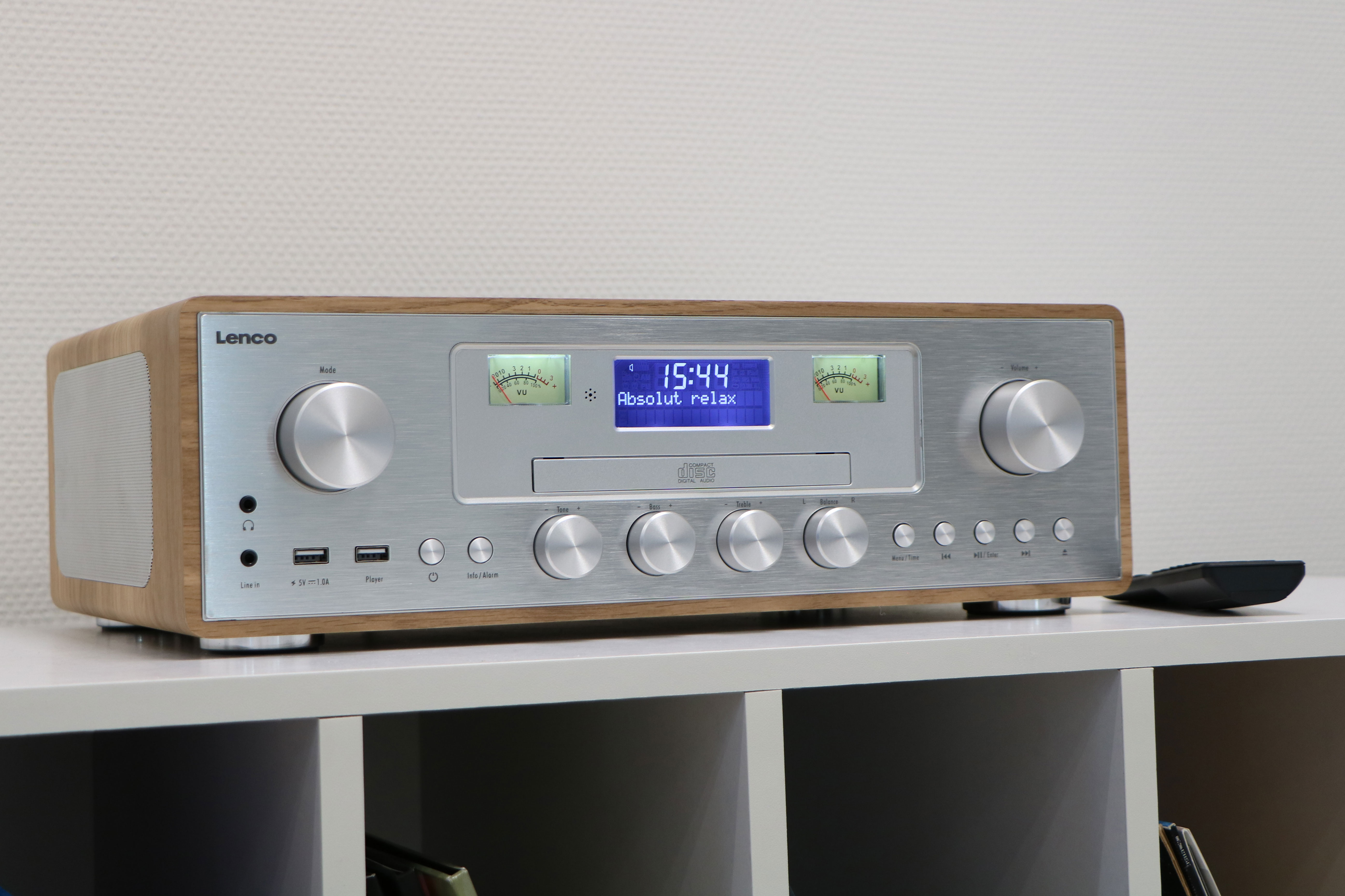 Houten en zilveren radio op een witte plank.