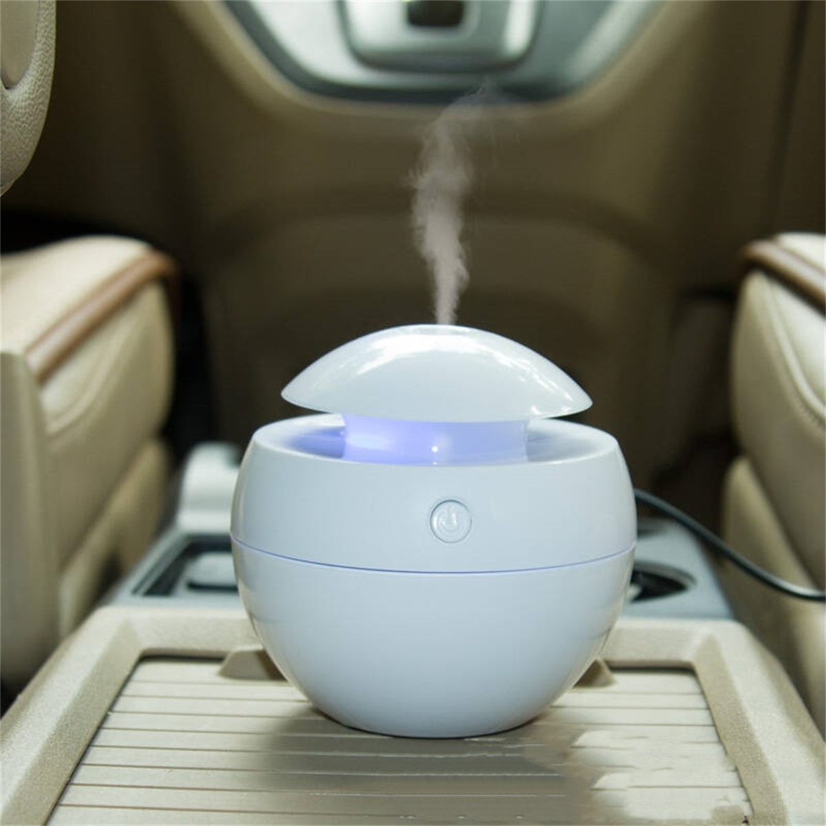 Weißer, eiförmiger Auto-Luftbefeuchter mit blauem Licht. Er steht in der Mittelkonsole eines Autos.