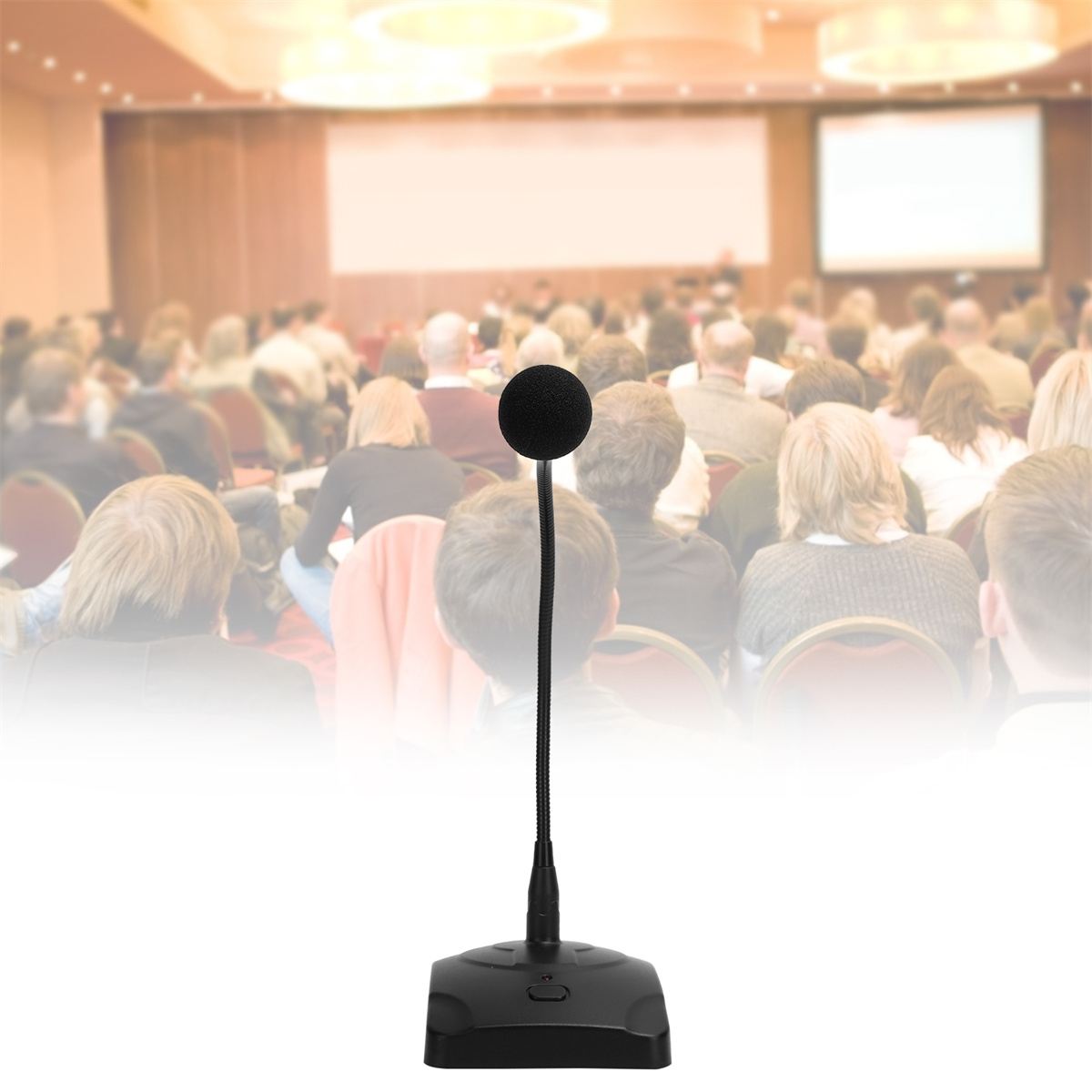 Mikrofon auf schwarzem Sockel, vor unscharfem Publikum auf einer Konferenz.