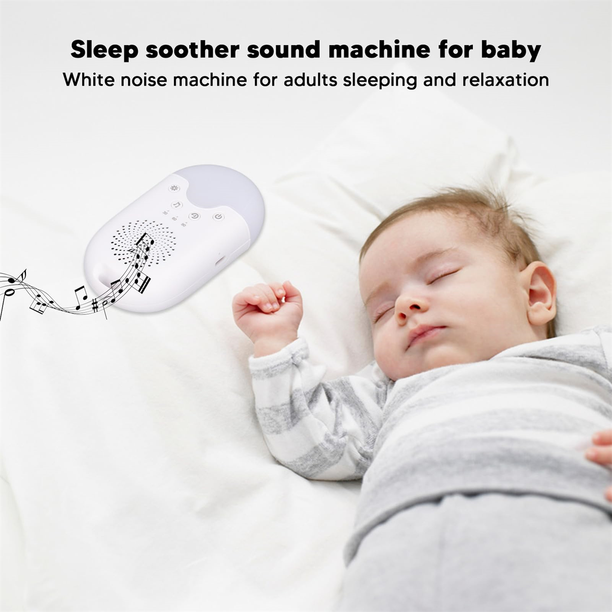 Baby schläft auf weißem Laken mit einer Klangmaschine, die Noten abspielt.